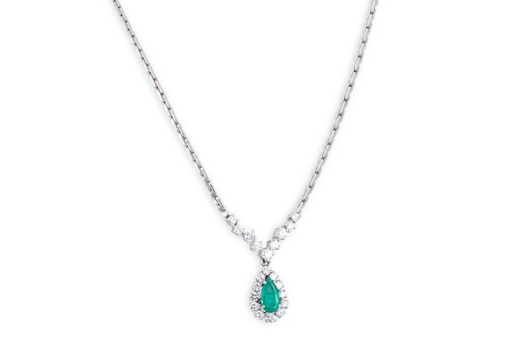 AN EMERALD AND DIAMOND SET CLUSTER PENDANT