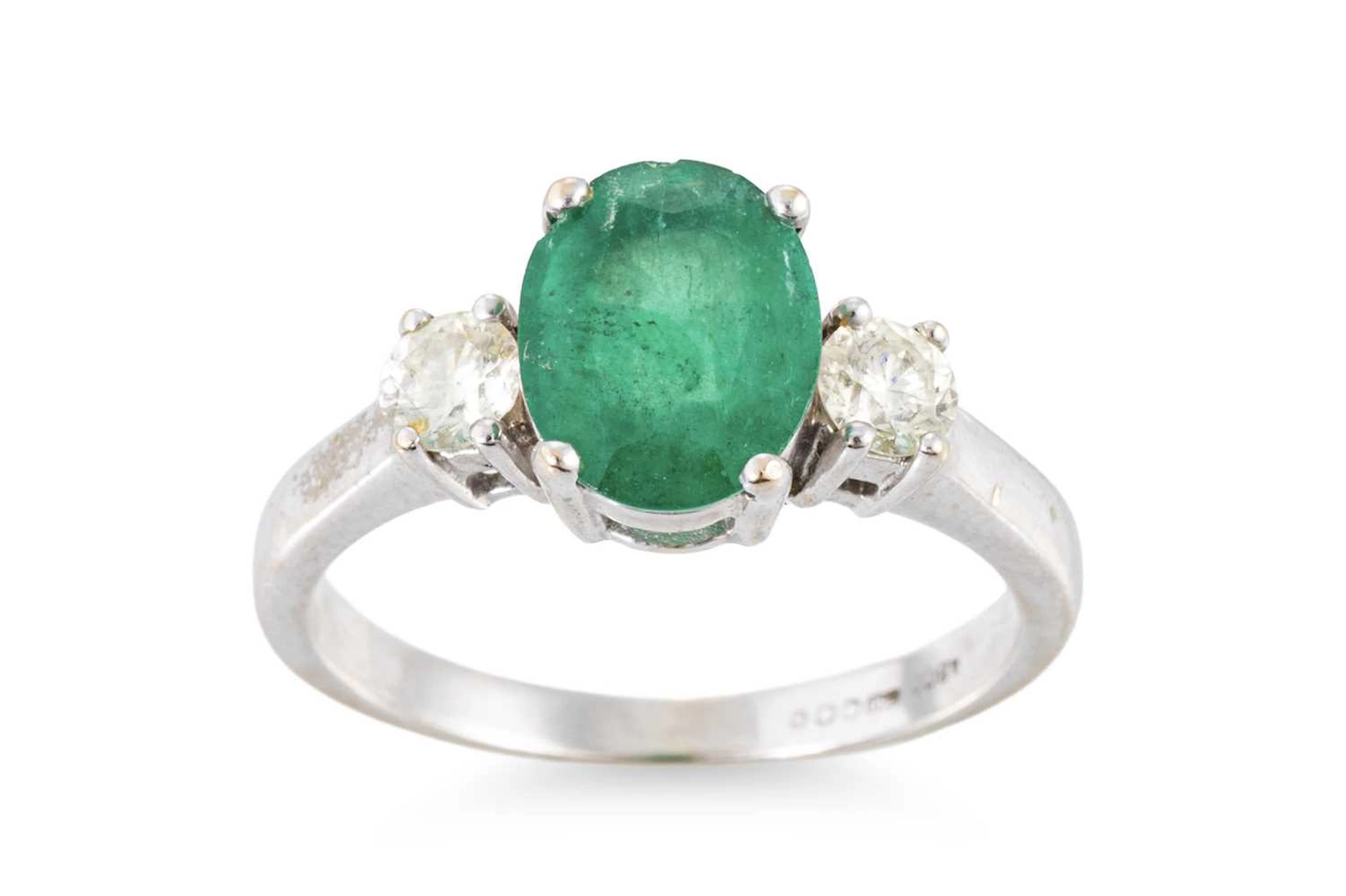 AN EMERALD AND DIAMOND THREE STONE RING