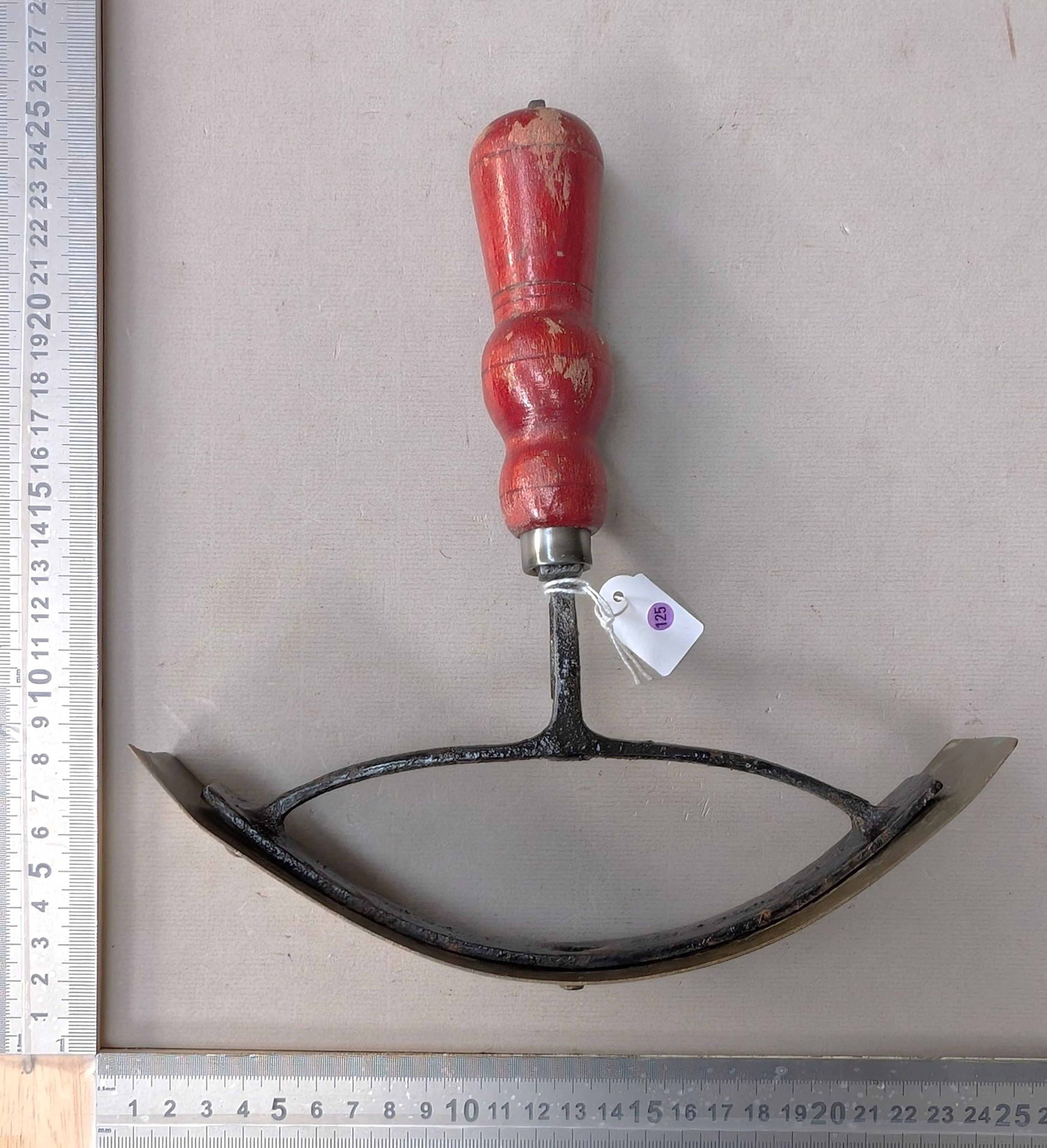 Horse sweat scraper, bronze and steel with a turned wooden handle—see