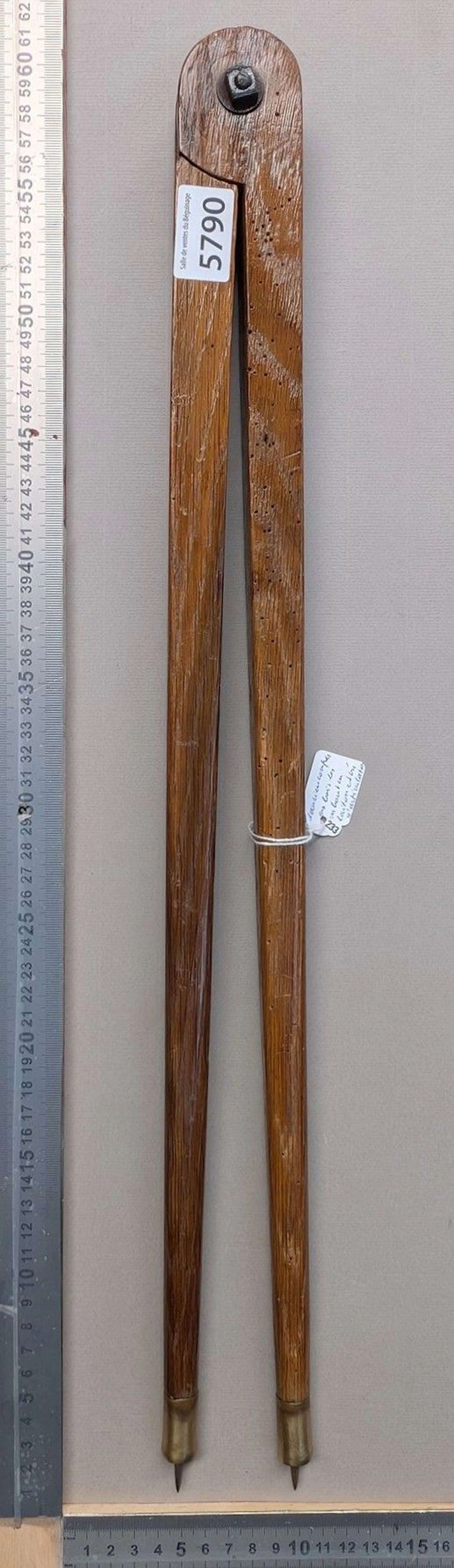 An old wooden compass with brass tips and a screw hinge—see photos
