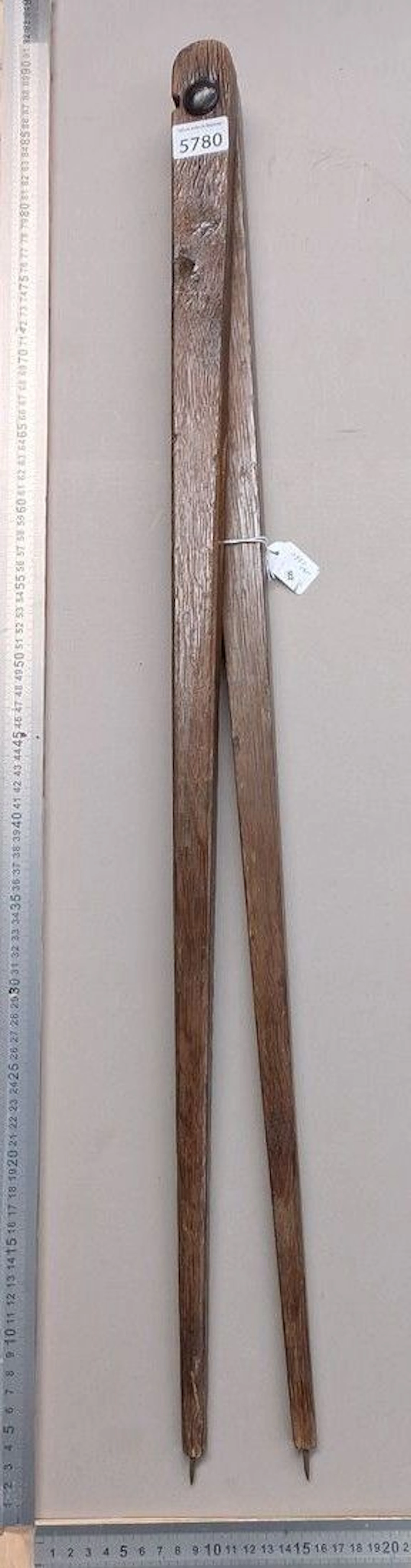 An antique wooden compass with a steel needle and a screw hinge—see