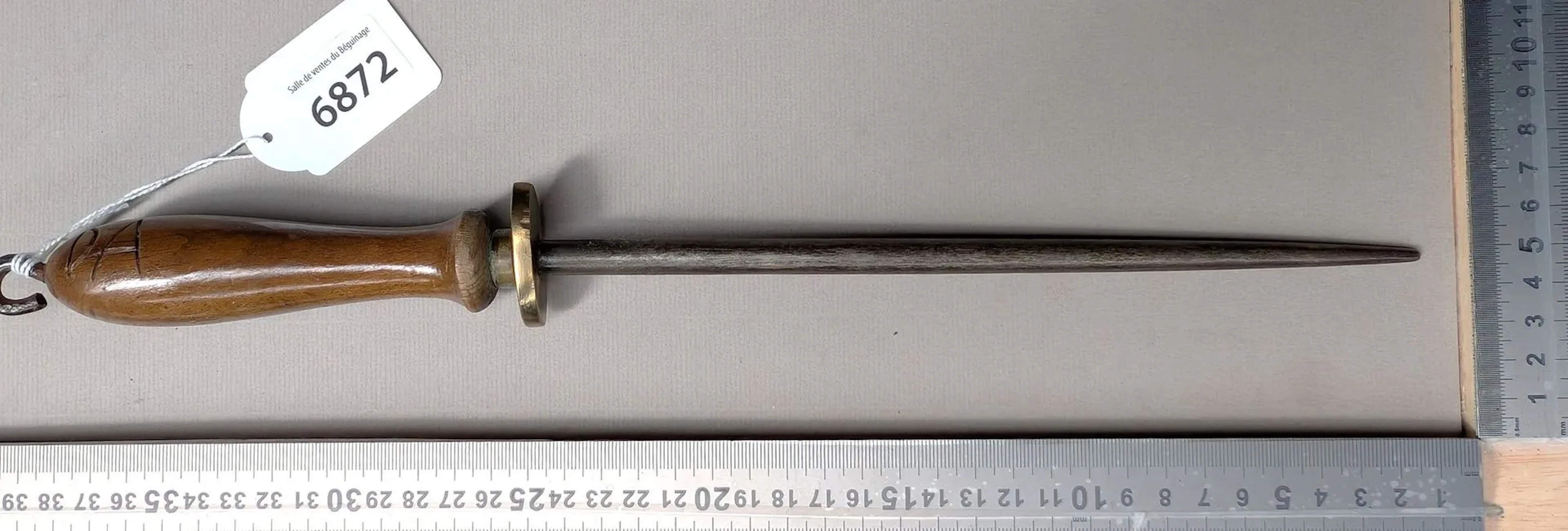 Antique butcher's sharpening knife with wooden handle, 20th century—see