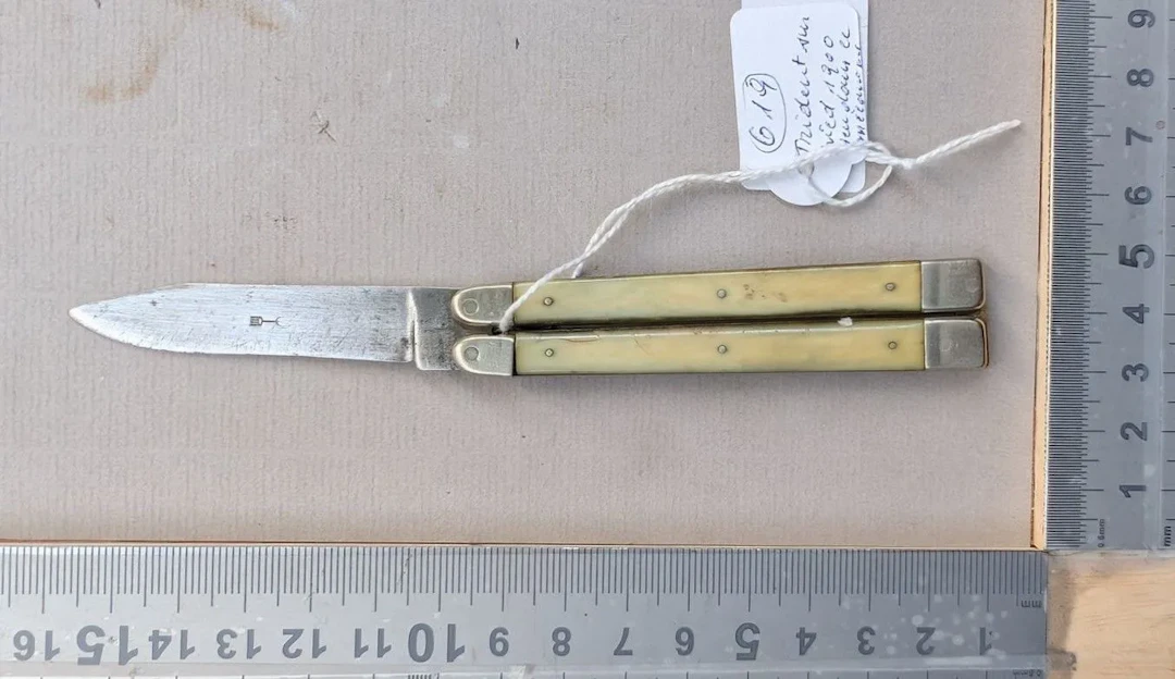 Stamped butterfly-style knife, fork, or trident on a stand, 1900—see