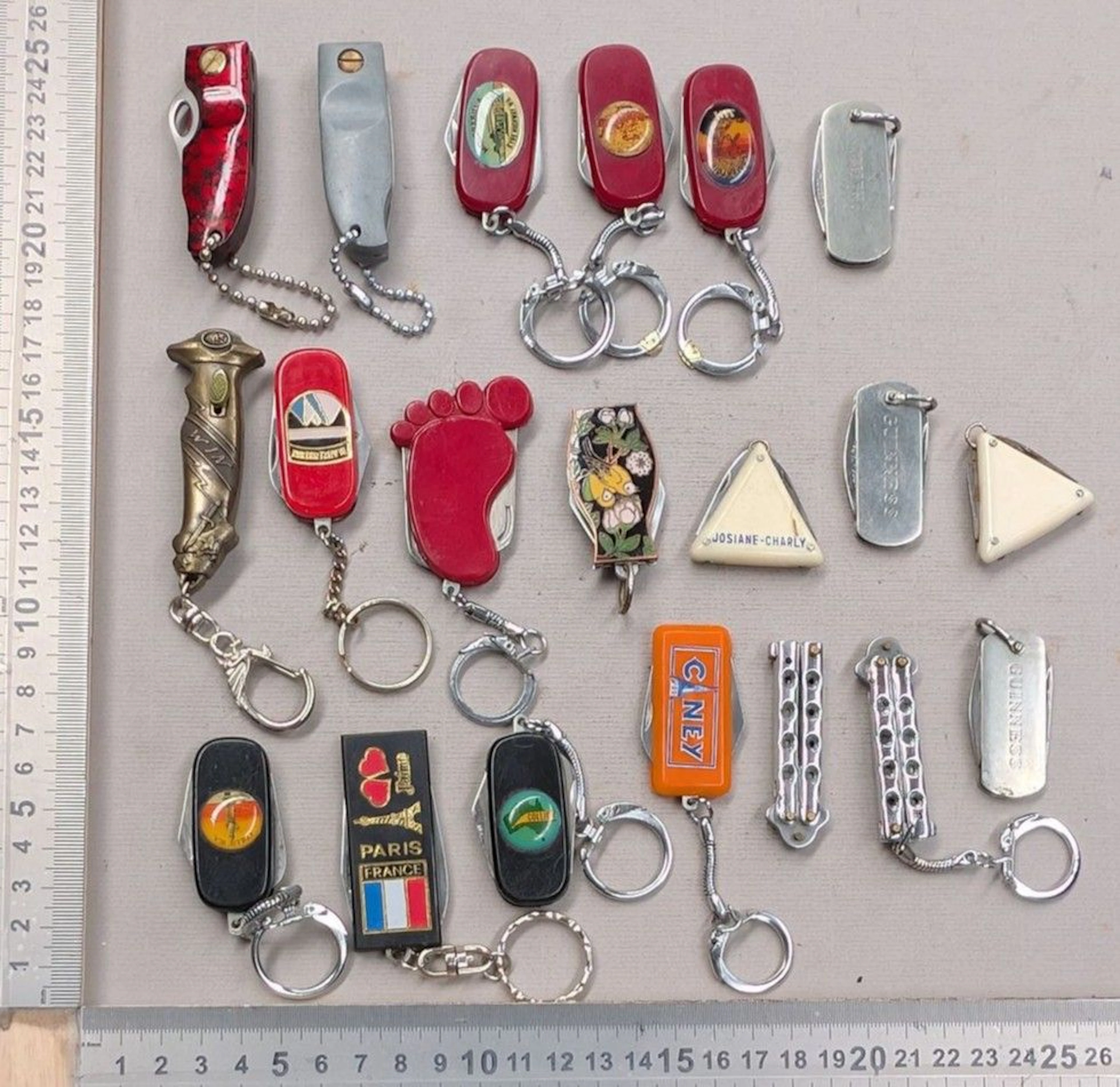 20 mini promotional and souvenir keychain pocket knives from the 1960s—see