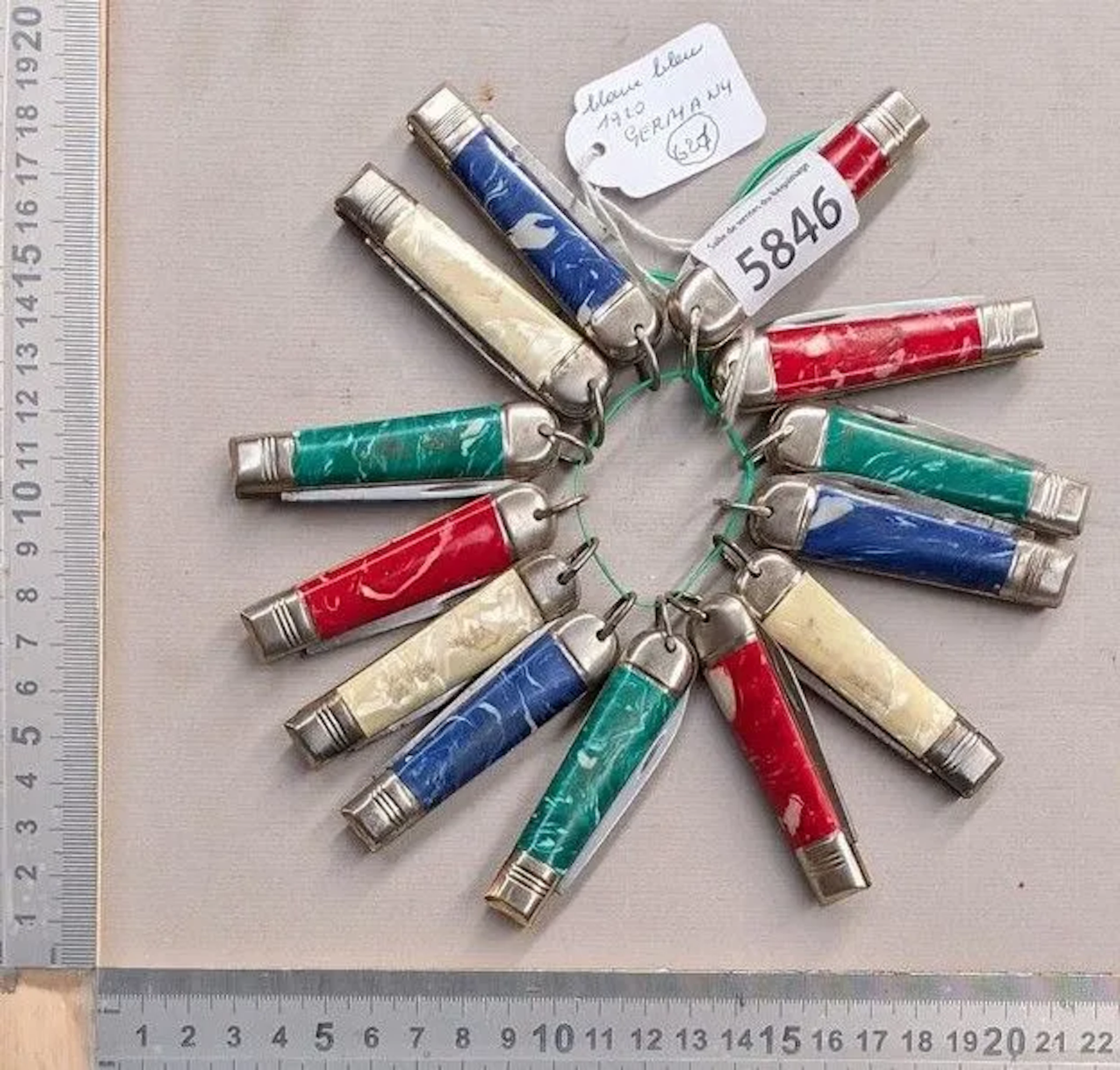 Set of 13 small pocket knives with decorative red, green, white, and