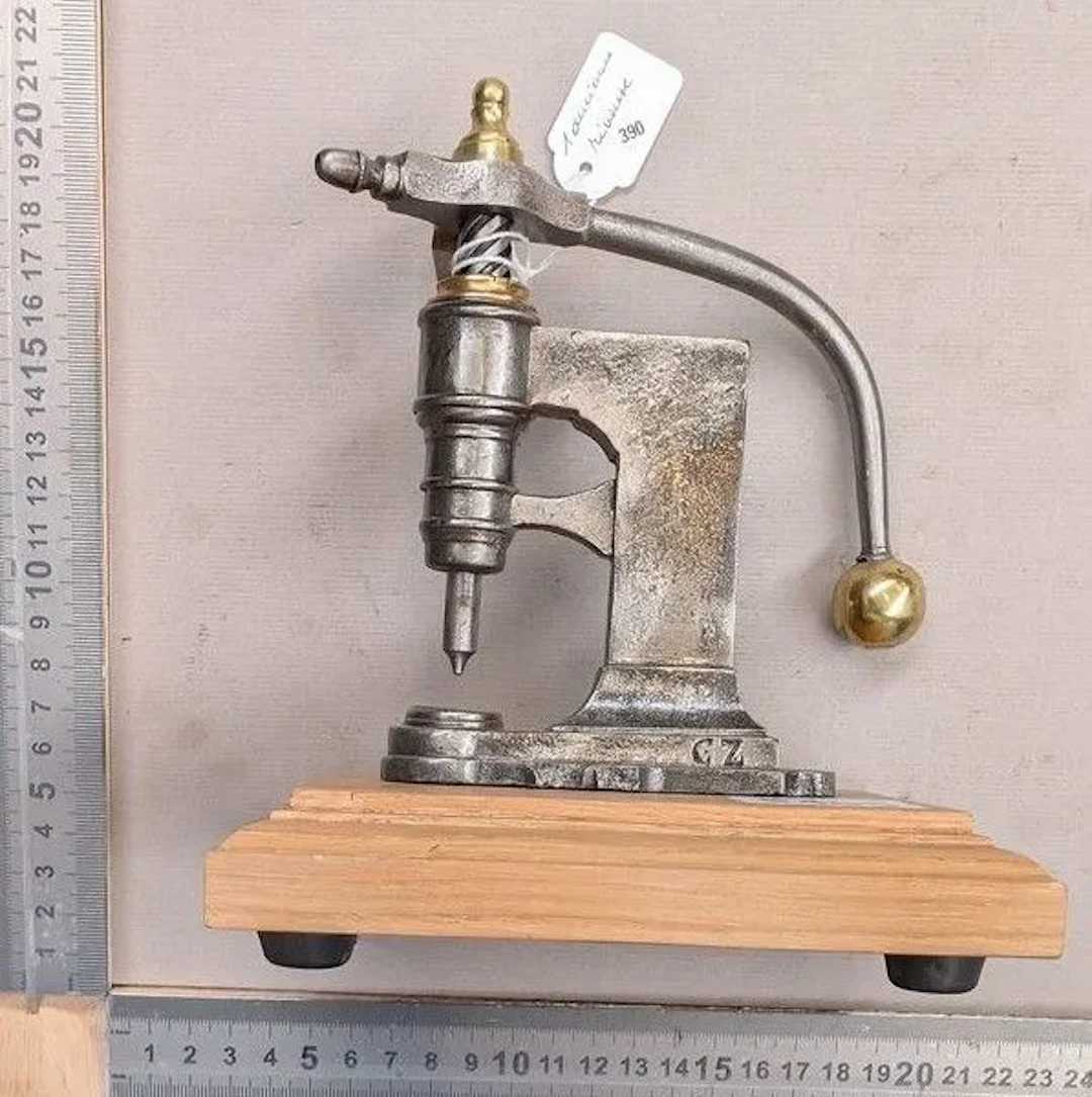 An antique rivet gun on its wooden base—see photos for dimensions and condition