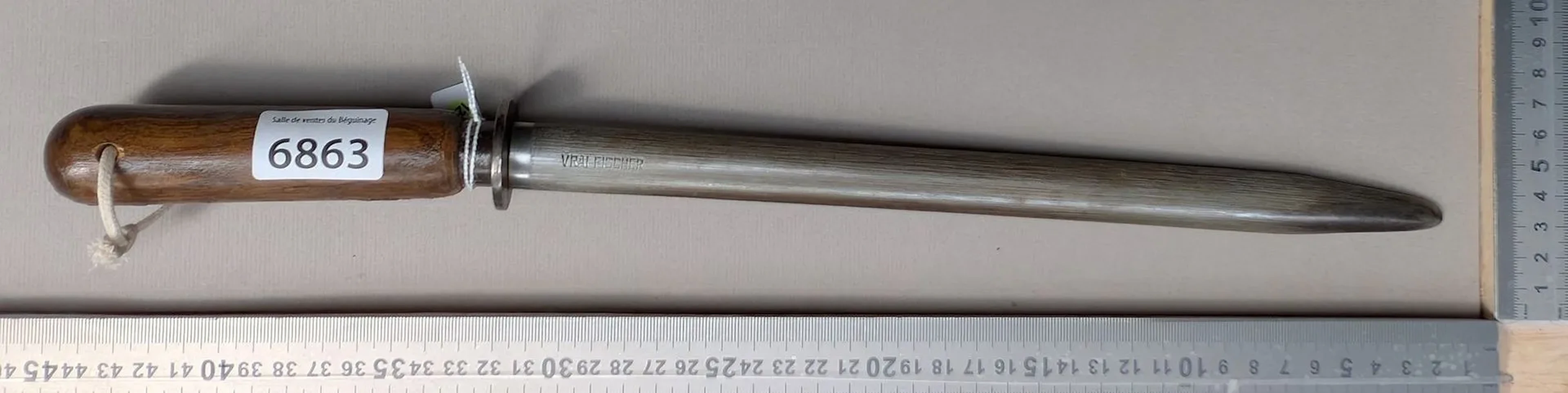 Antique butcher's sharpening knife with wooden handle, 20th century—see
