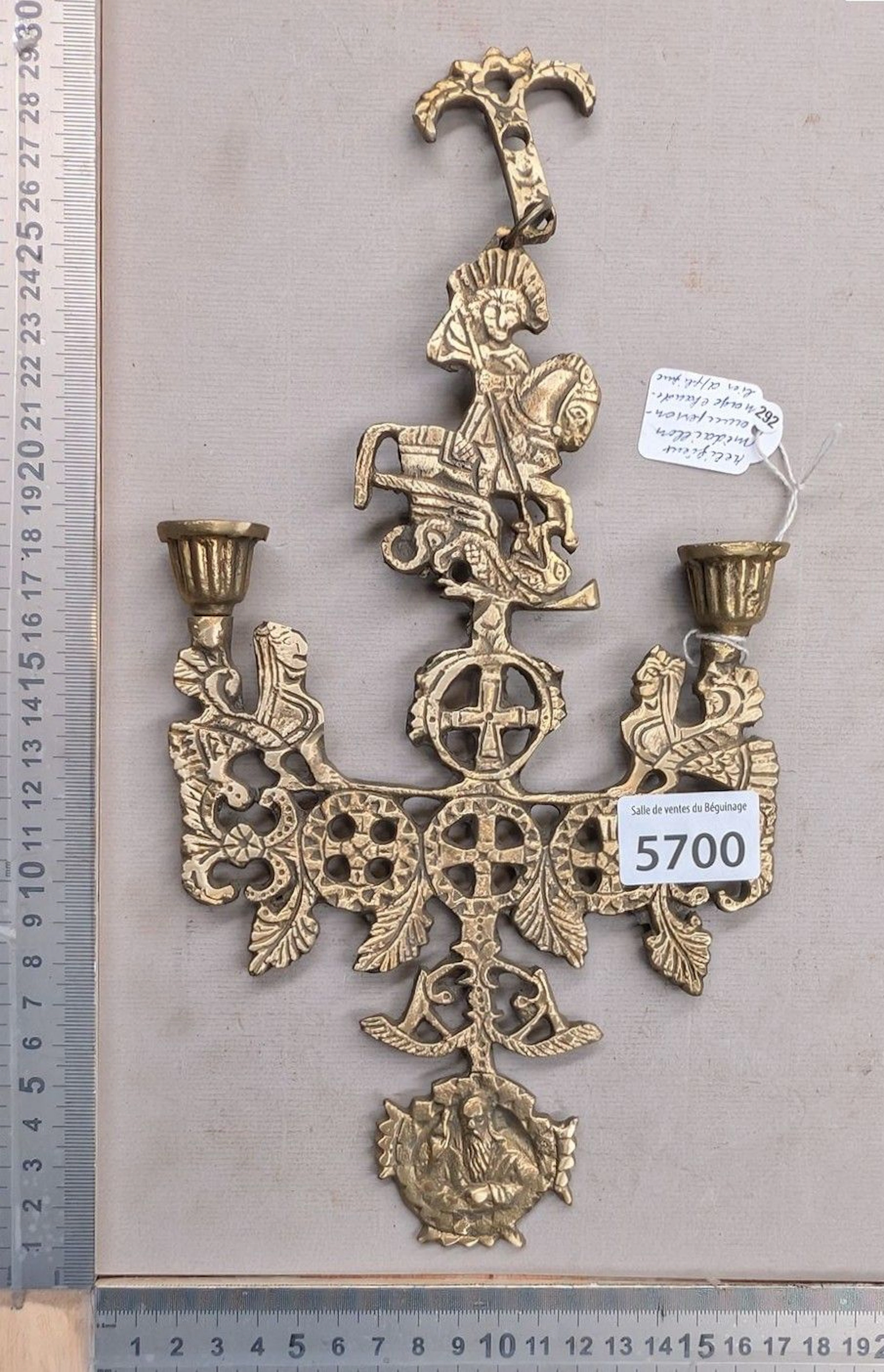 Relics, medallions featuring figures, candlestick, votive sconce—see