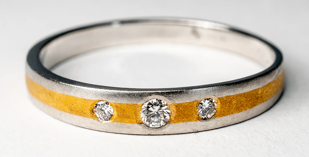 Lot 257: PLATINUM AND GOLD TWO-TONE RING WITH 3 SMALL DIAMONDS