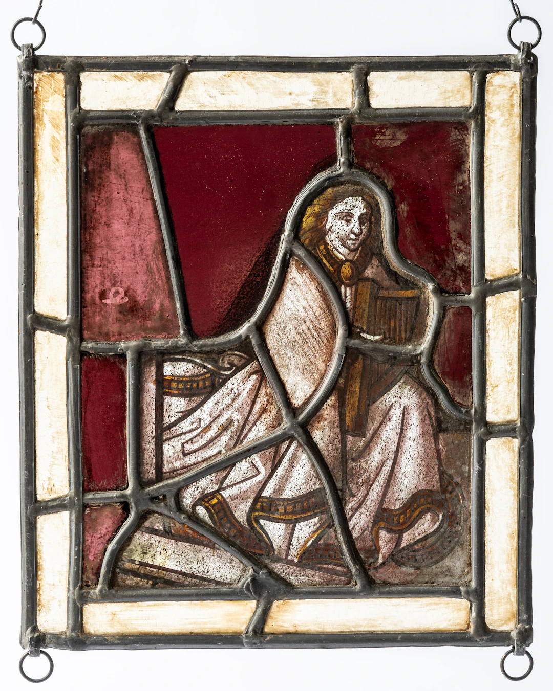 Lot 93: FRAGMENT OF A STAINED GLASS WINDOW SHOWING A KNEELING WOMAN WITH A HARP