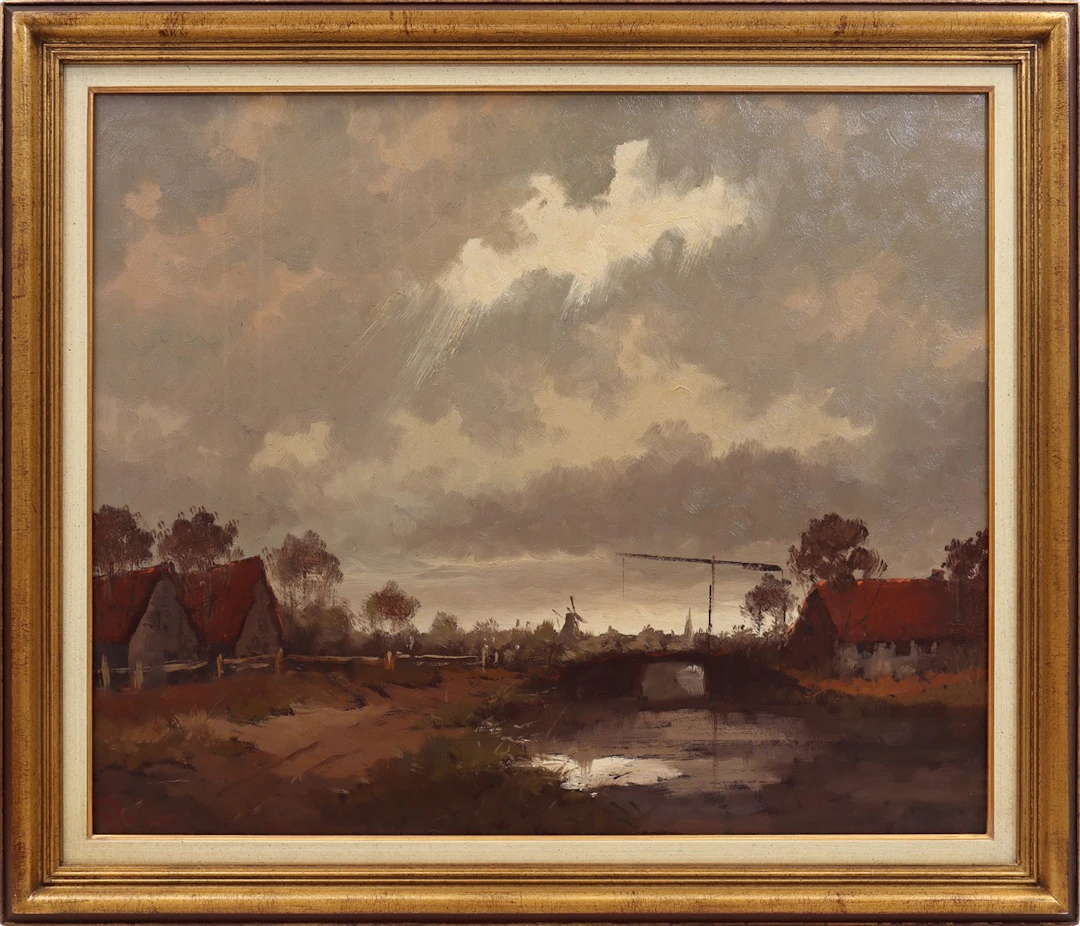Landschap met huizen aan rivier met brug bij stormachtige lucht