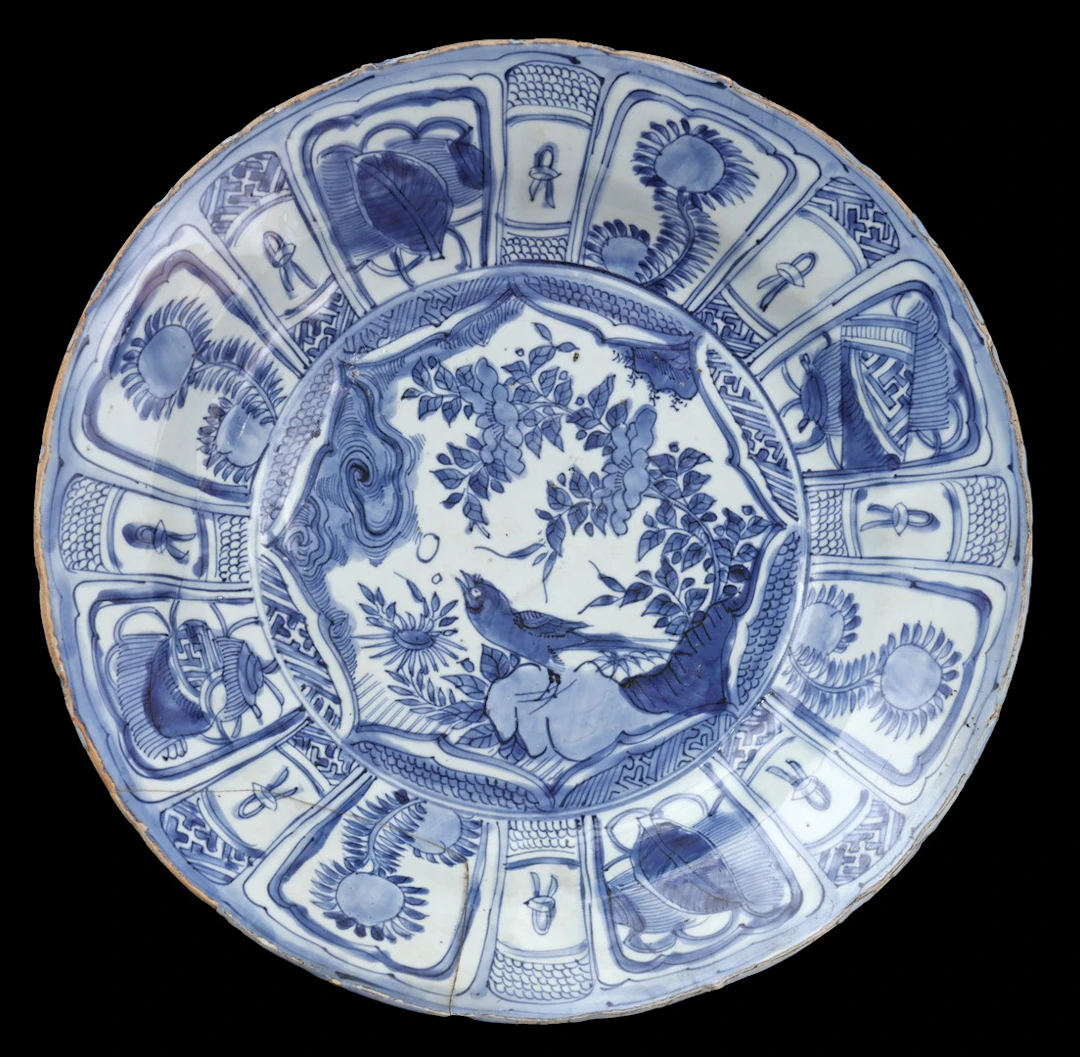 Porseleinen schotel met blauw decor van vogel op rots