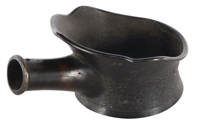 Bronzen kom met hengsel voorzien van oosters decor rondom met patronen