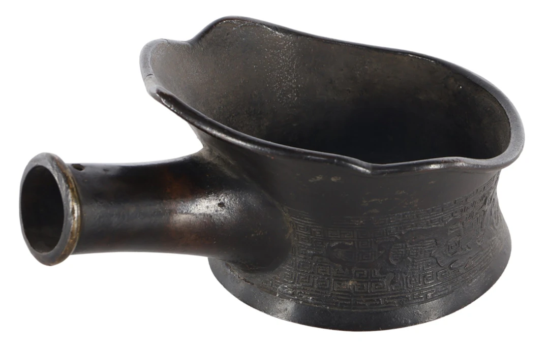 Bronzen kom met hengsel voorzien van oosters decor rondom met patronen