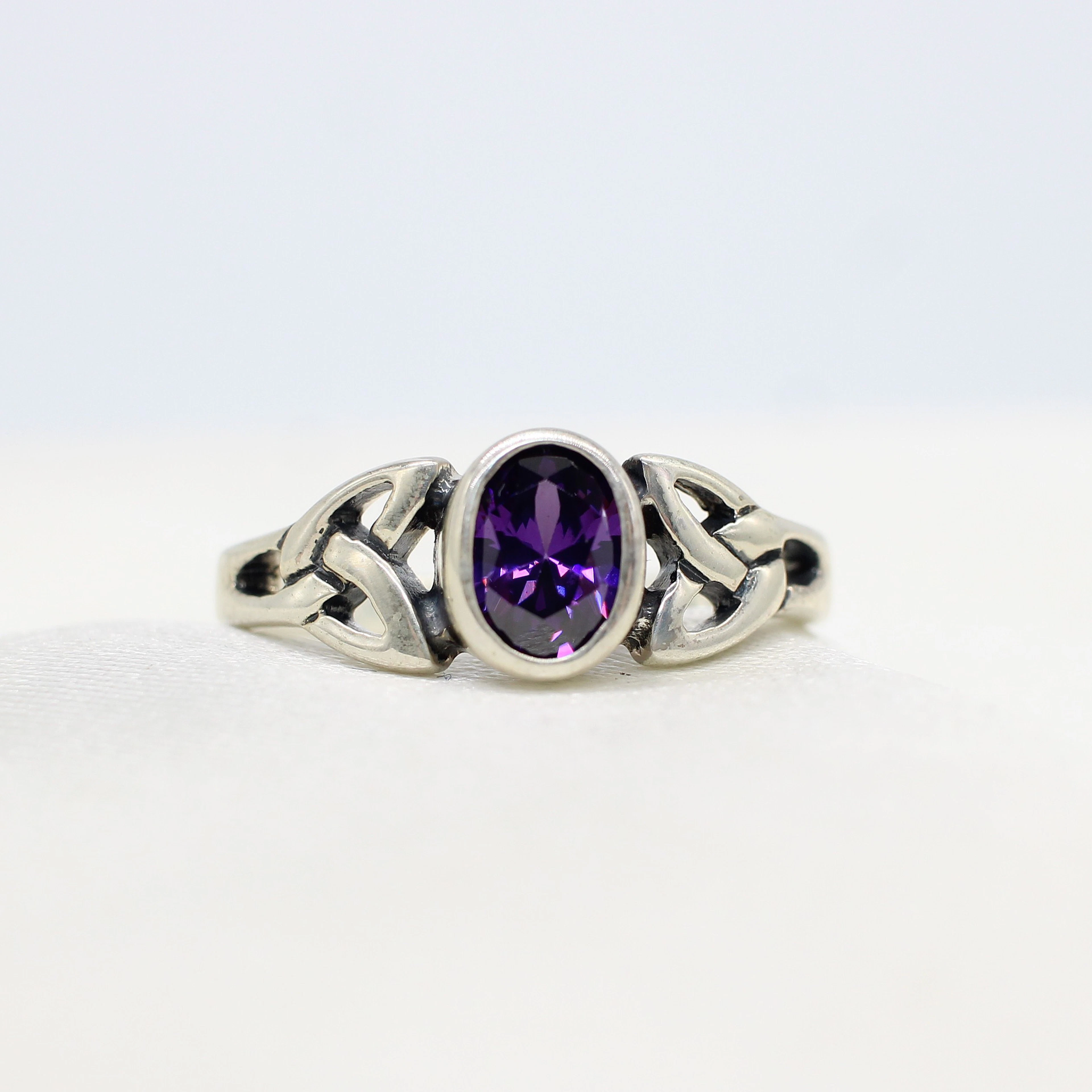 SILVER CELTIC RING WITH PURPLE CUBIC ZIRCONIA.