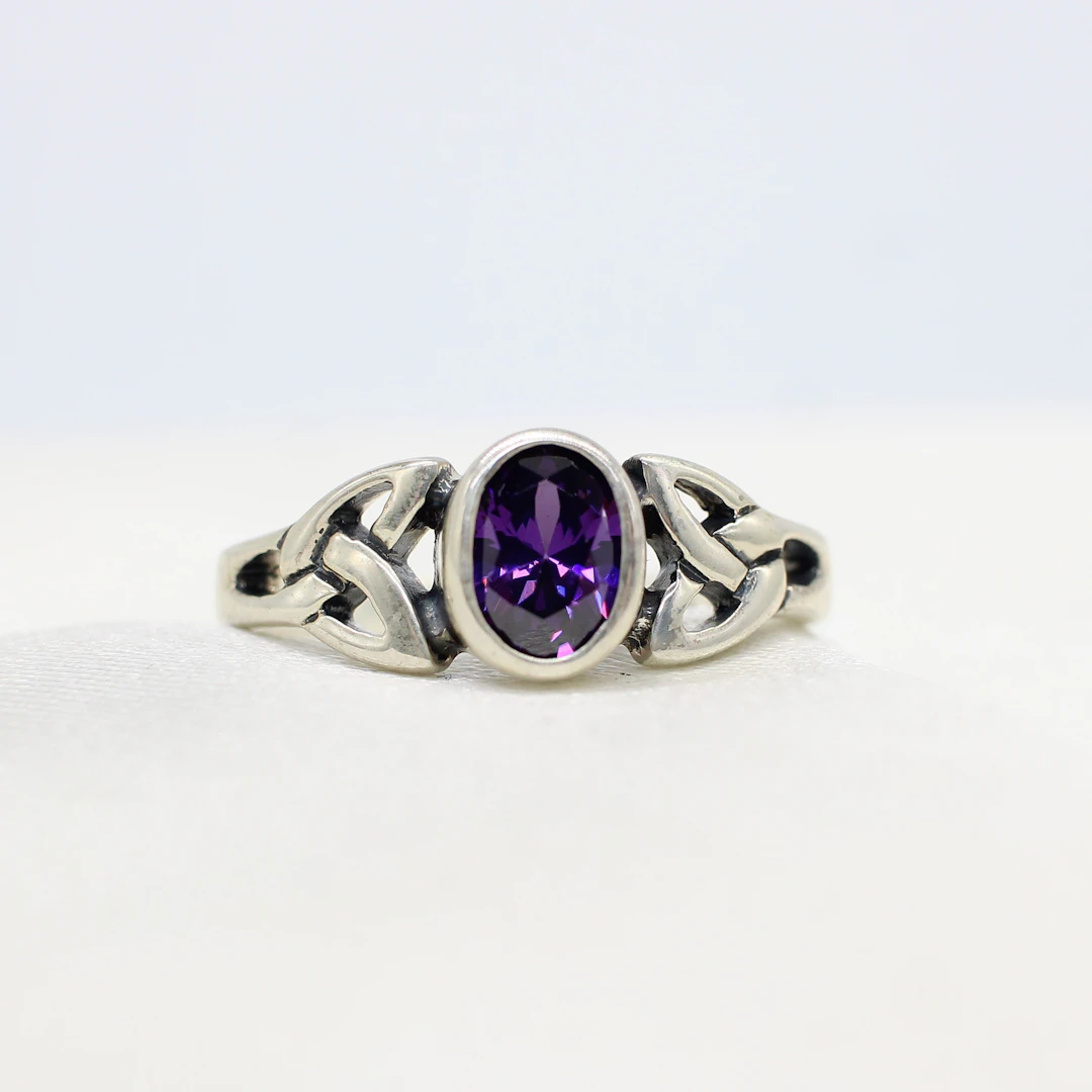 SILVER CELTIC RING WITH PURPLE CUBIC ZIRCONIA.