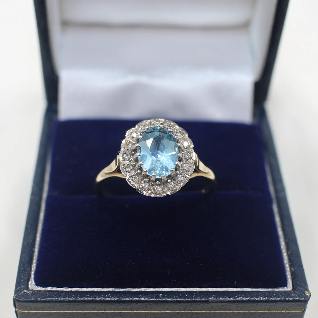 BLUE TOPAZ & DIAMOND CLUSTER RING.