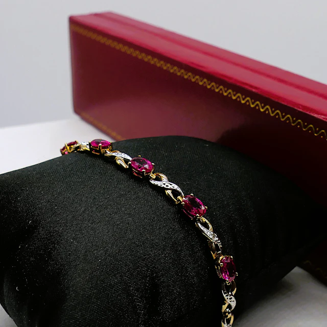 YELLOW GOLD BRACELET SET WITH CREATED OVAL RUBIES AND DIAMONDS.