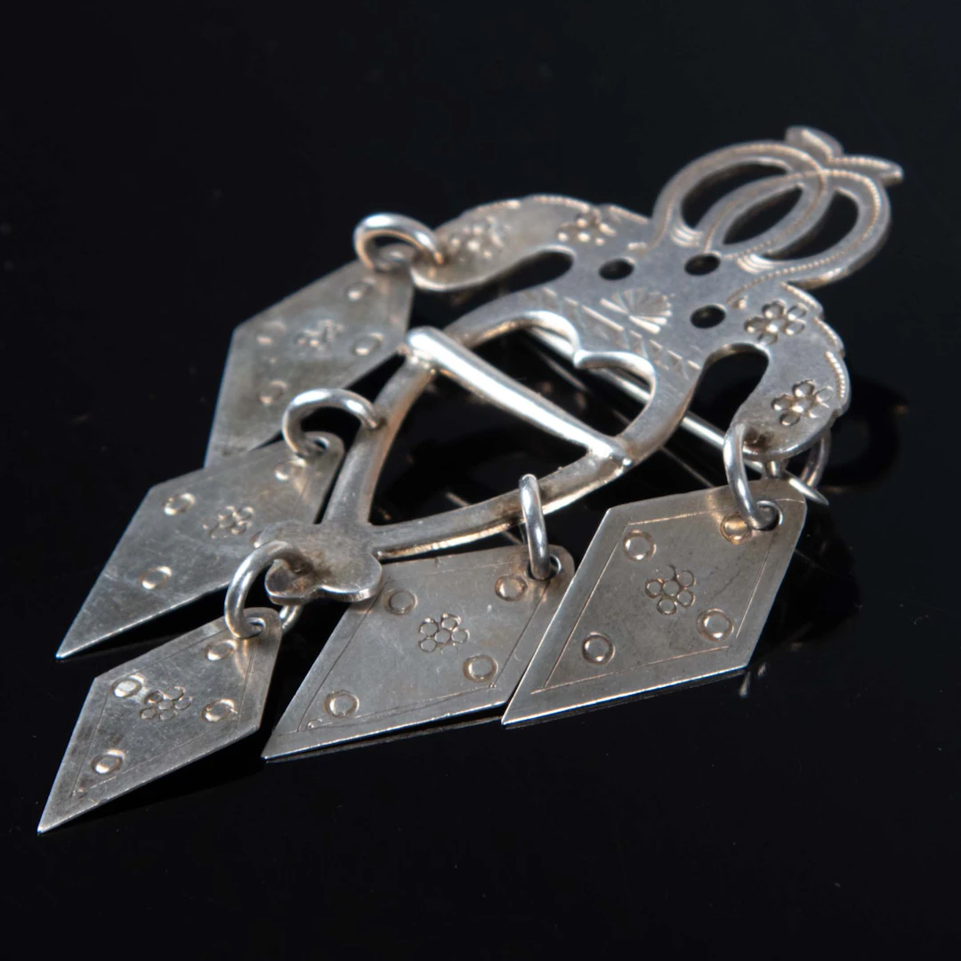 DRÄKTSMYCKE, silver, C.G. Hallberg, Stockholm, 1897.