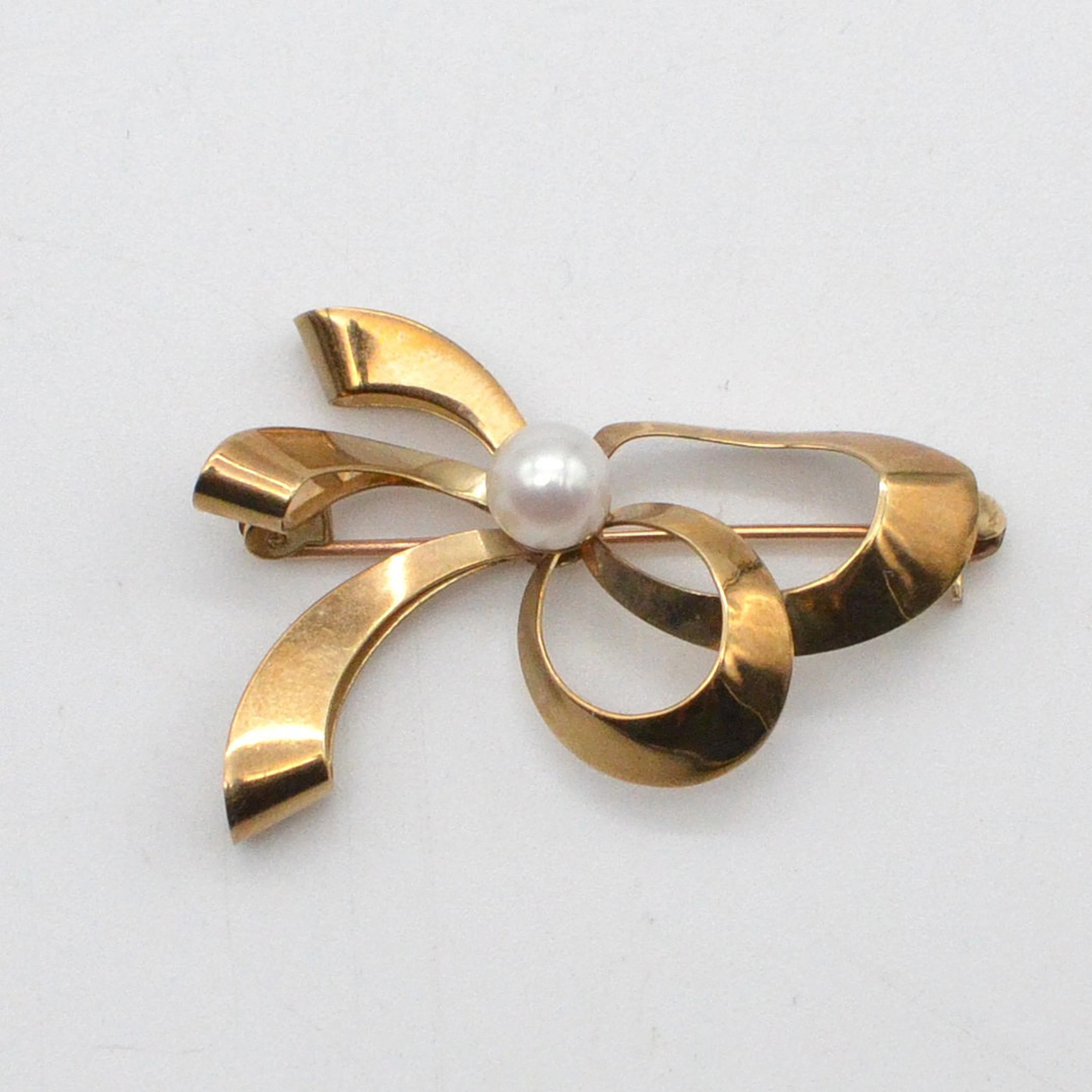 HERMANN SIERSBØL. DESIGNER BROSCHE, SCHLAUFE MIT PERLE, 8 KARAT GELBGOLD