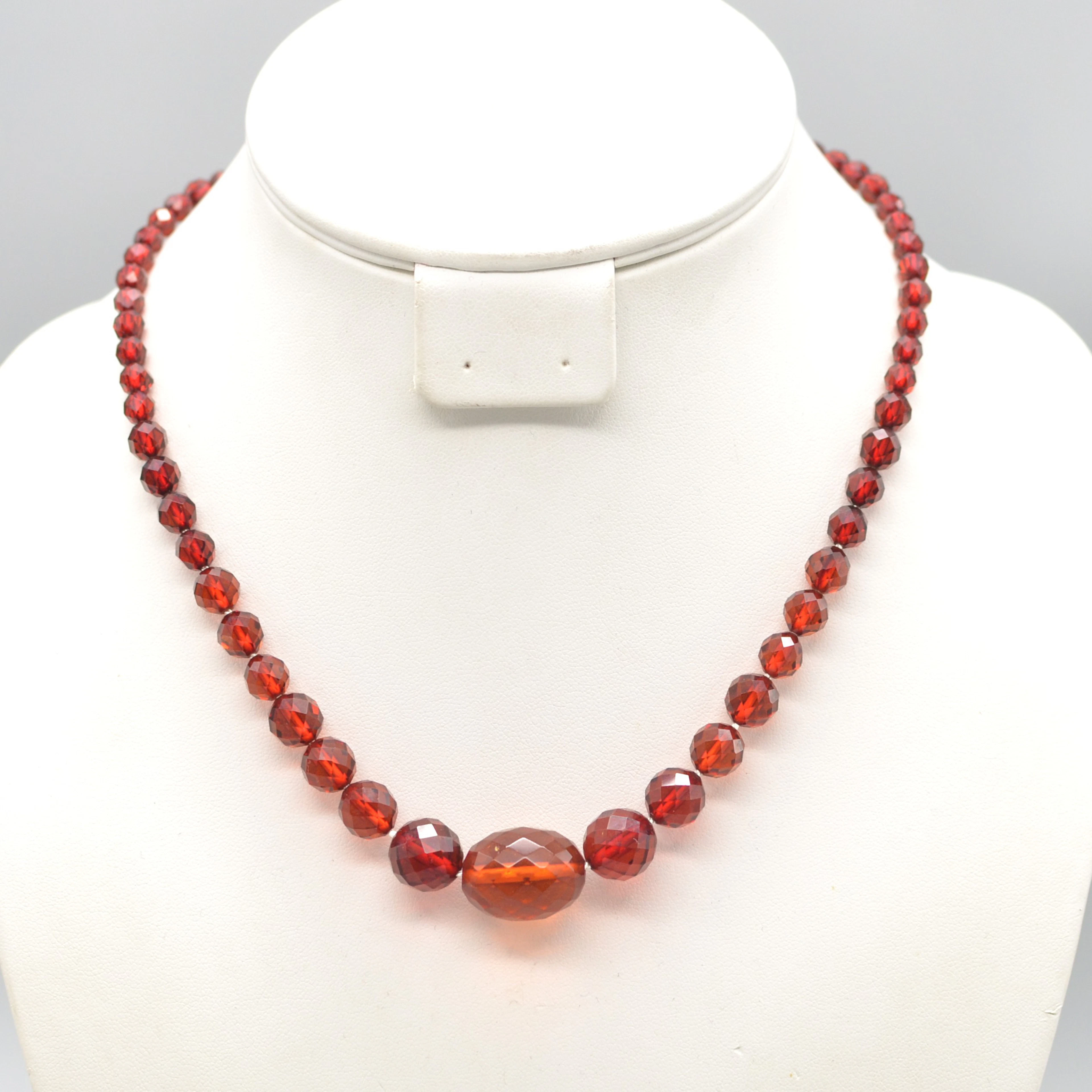 ART DECO BAKELIT PERLENCOLLIER MIT EINEM ROTEN BERNSTEIN, FACETTIERT