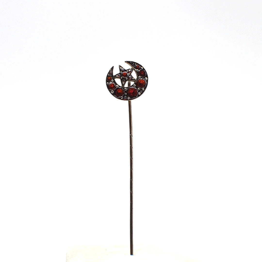 JUGENDSTIL KRAWATTENNADEL MIT GRANATEN, MOND UND STERN, UM 1900.