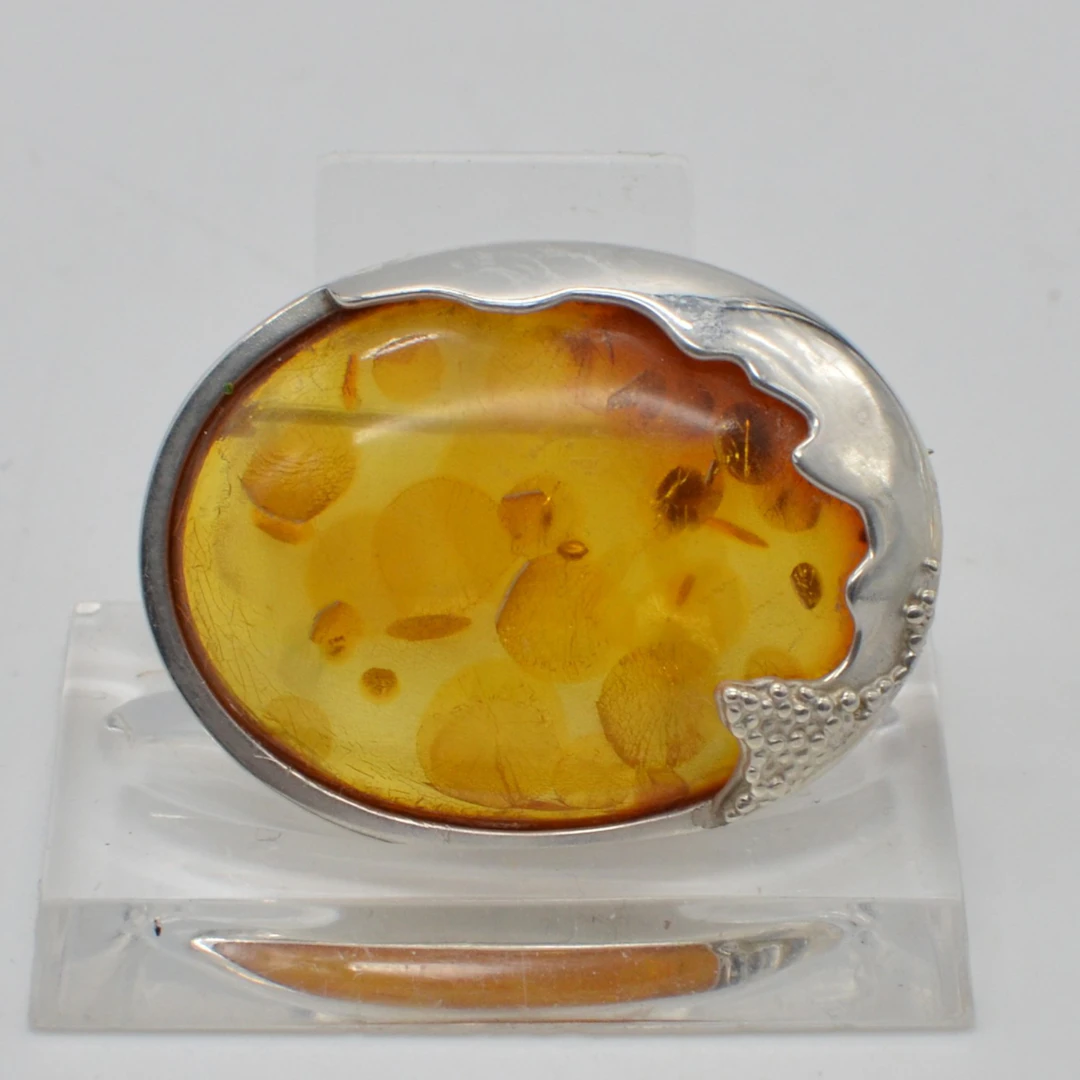 DESIGNERBROSCHE MIT BERNSTEINCABOCHON, BLATTEINSCHLÜSSEN, HANDGEMACHTE