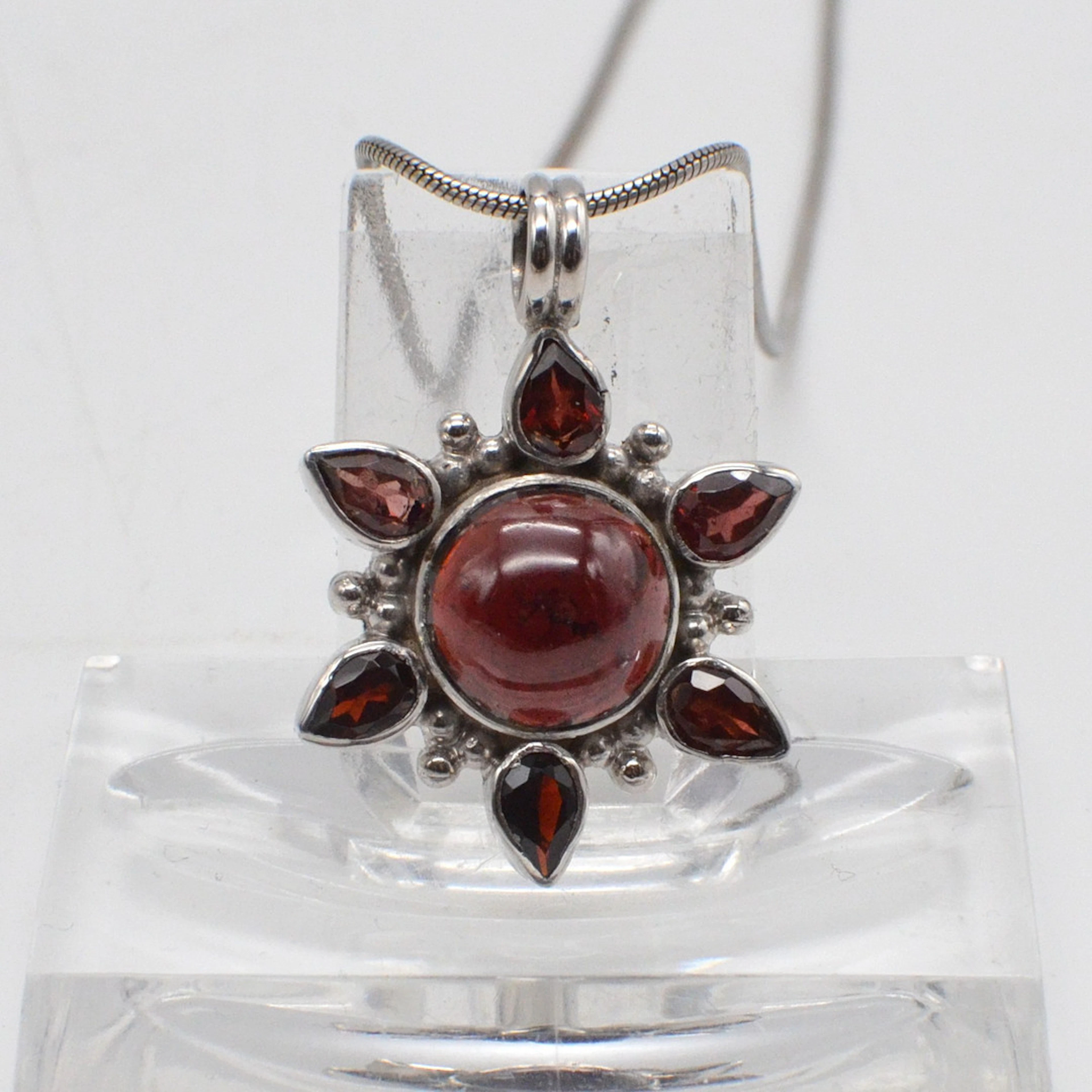 COLLIERANHÄNGER MIT ALMANDIN "SONNE", CABOCHON UND TROPFENFORM, FASSUNG