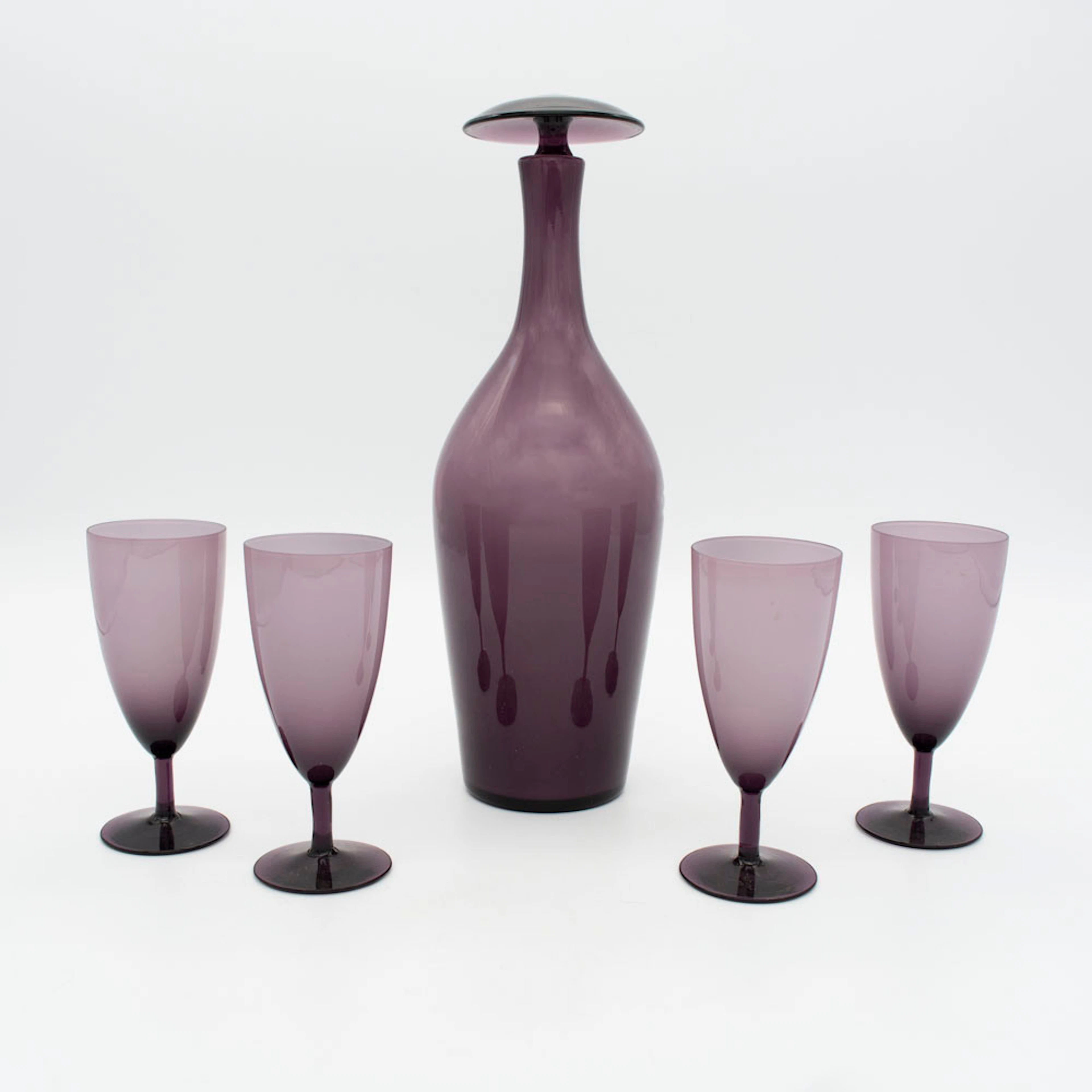 HANDGEMACHTE KARAFFE MIT VIER STIELGLÄSERN, GLAS, VIOLETT UND WEISS, UM 1960.