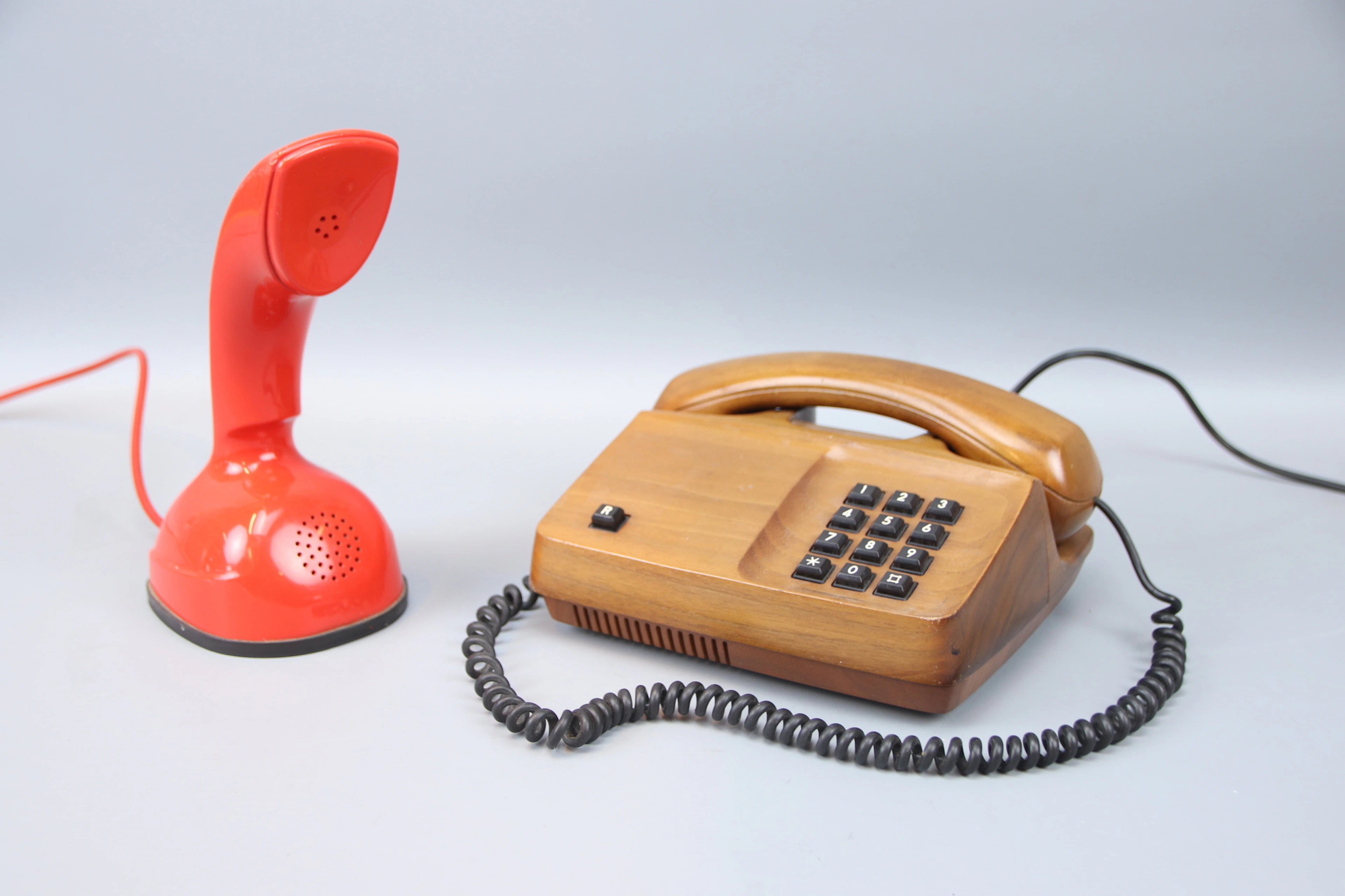 Kobratelefon och knapptelefon, plast/valnöt.