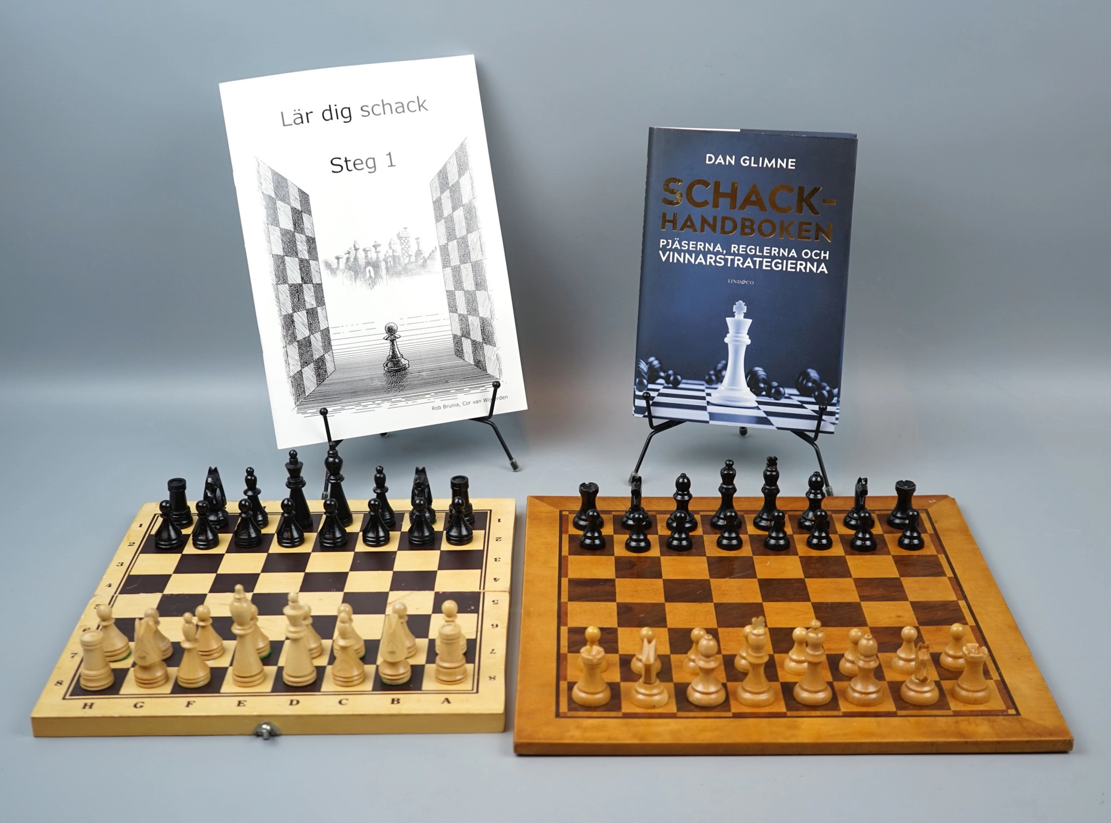 Partidas de ajedrez, 2 completas, de madera y 2 libros sobre ajedrez.