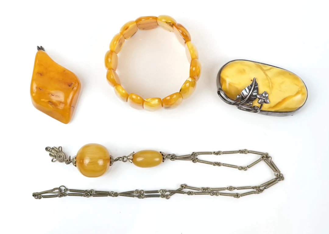 Jewellery, 4 pieces, amber, brooch with silver shoeing.