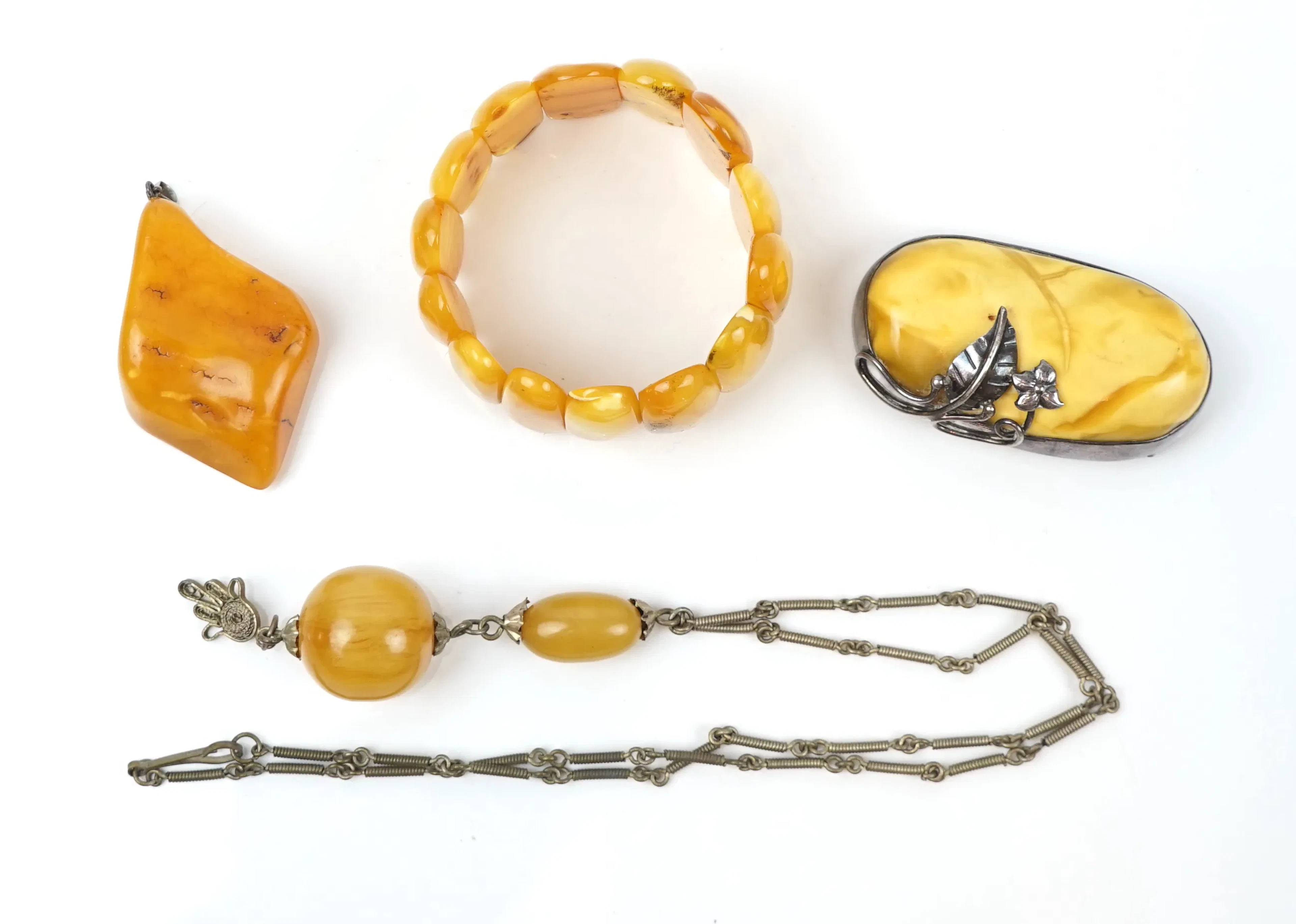 Jewellery, 4 pieces, amber, brooch with silver shoeing.