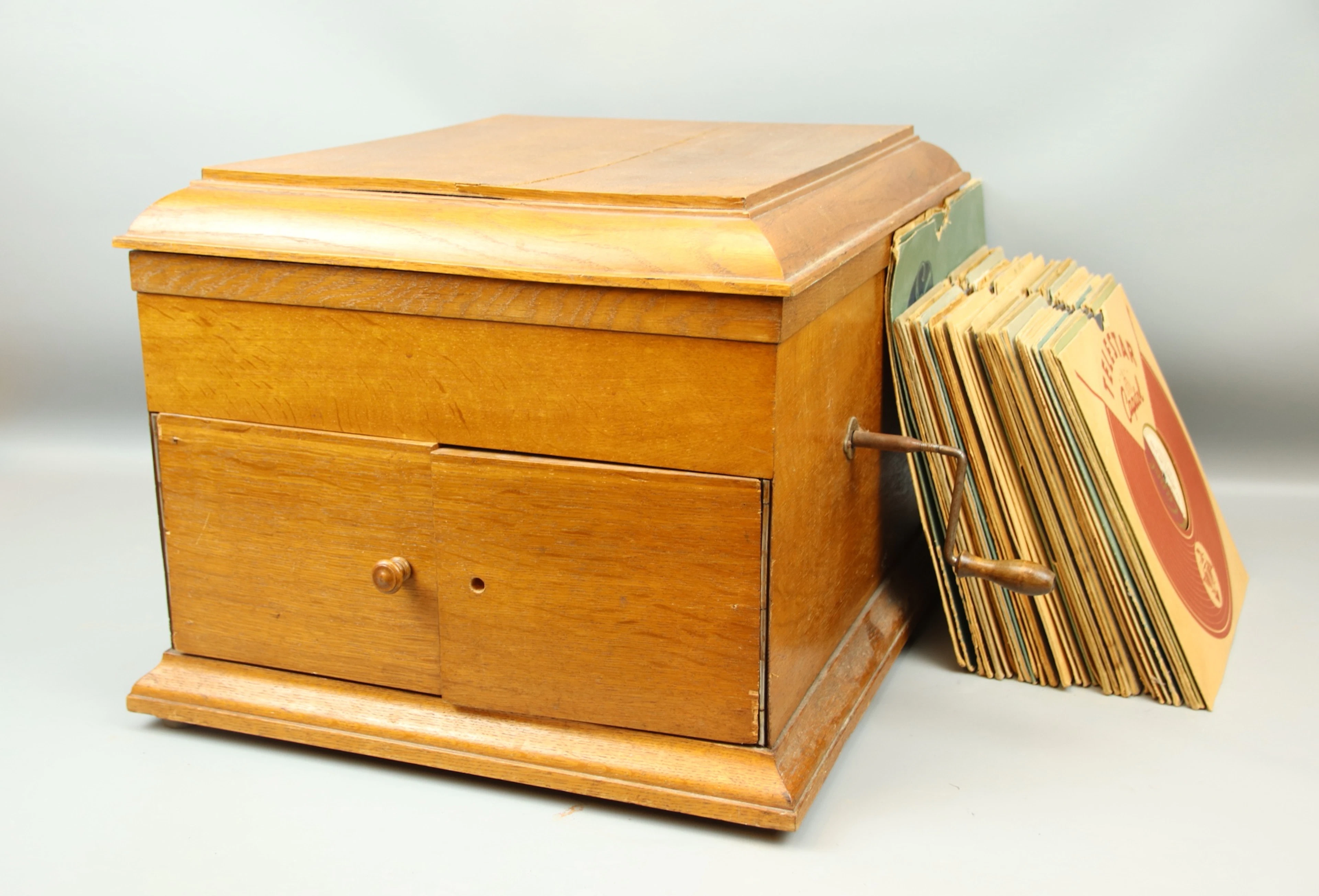 Grammofono a manovella, legno e torte di pietra.