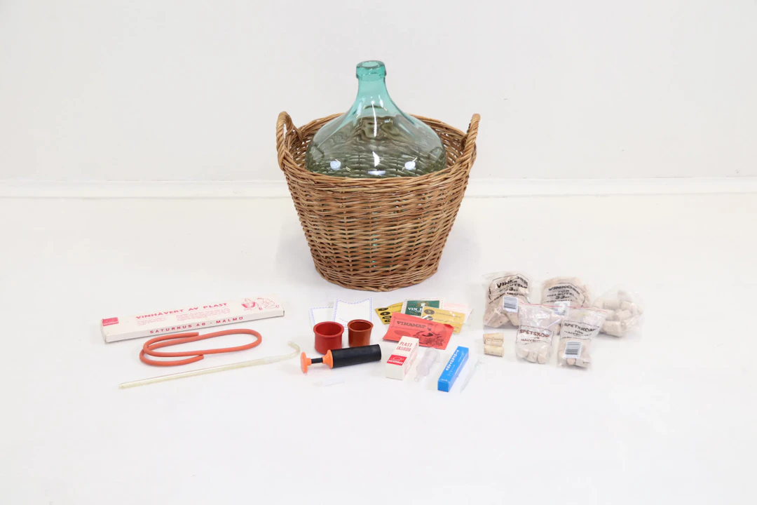Vaqueros de dama, vaso, cesta en la copa y accesorios para la elaboración de vino.
