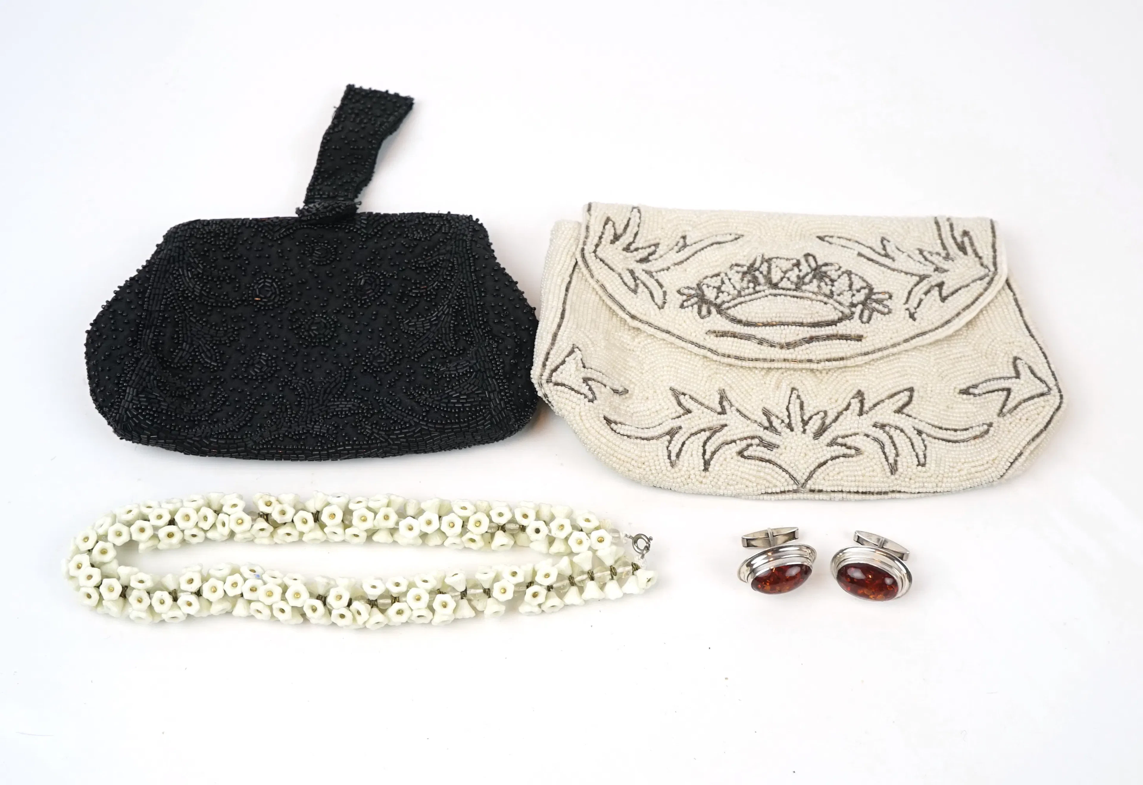 Cufflinks in silver, necklaces in glass and evening bags with pearl embroidery.