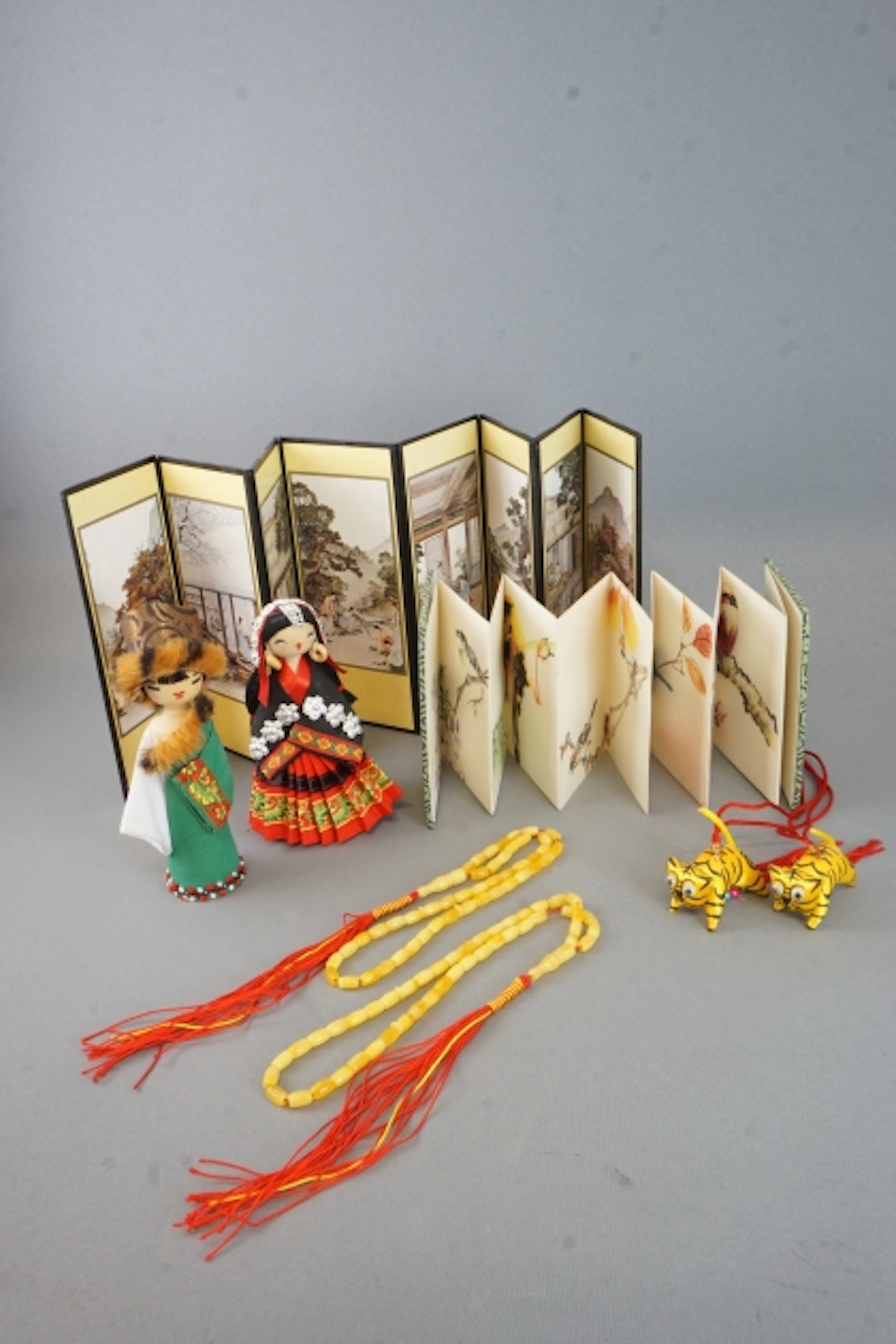 Samling asiatisk dekorativ konst- Miniatyrvikskärm, bildbok samt dockor