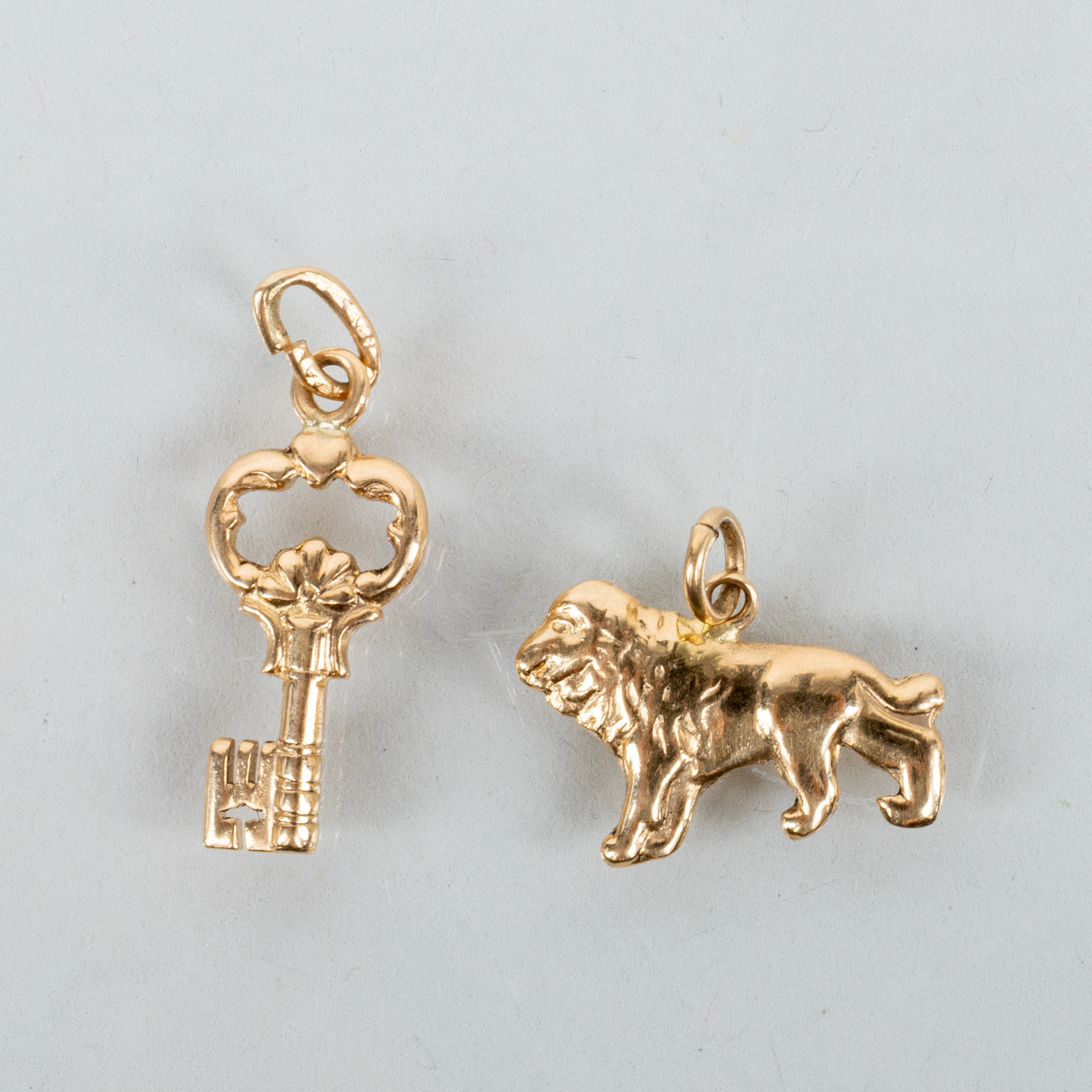 COLGANTES, 2 piezas, oro de 18 quilates, león y llave, segunda mitad del siglo XX