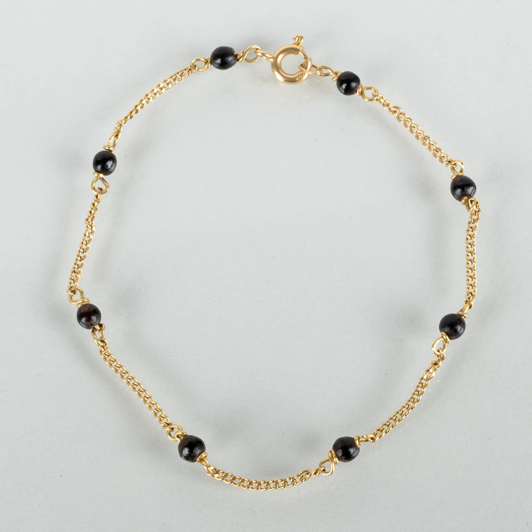 BRACELET, 18k gold, with black beads, probably the second half of the 20th century
