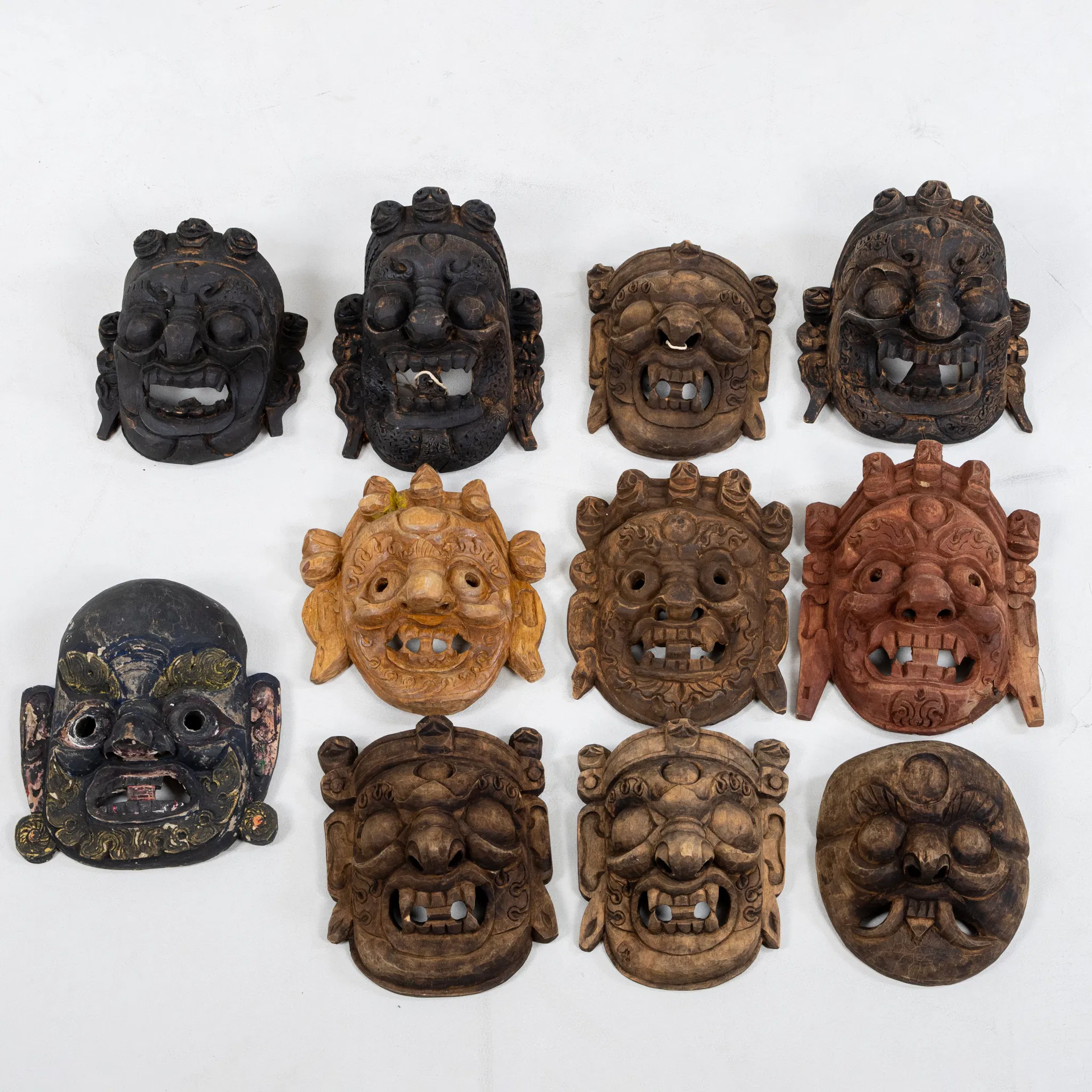 MASQUES MURAUX, 11 pièces, bois taillé, probablement Inde, années 1900