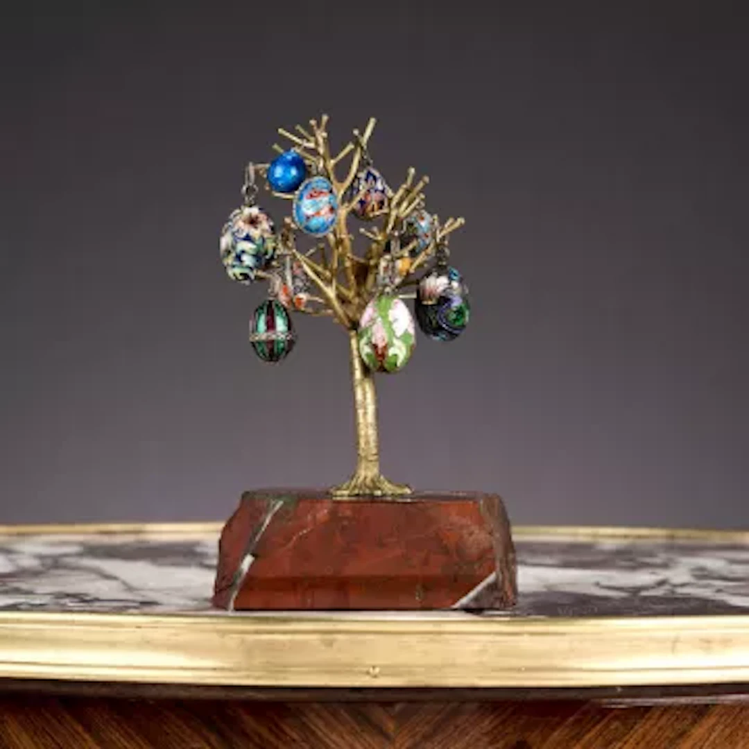 TEN RUSSIAN CLOISONNE ENAMEL AND SILVER EGG PENDANTS MOUNTED ON A STAND