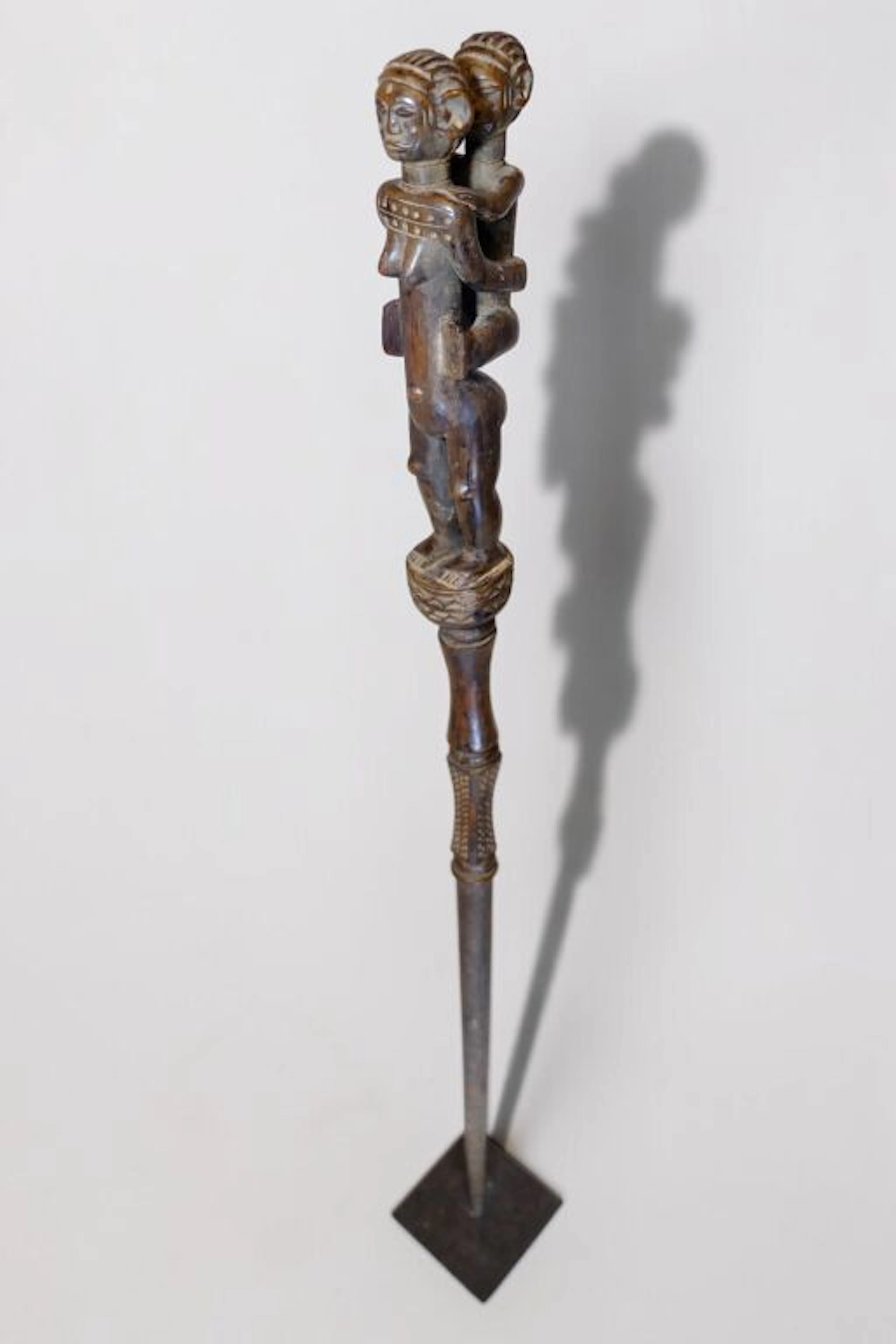 Ceremonial scepter made of carved, weathered wood depicting a mother