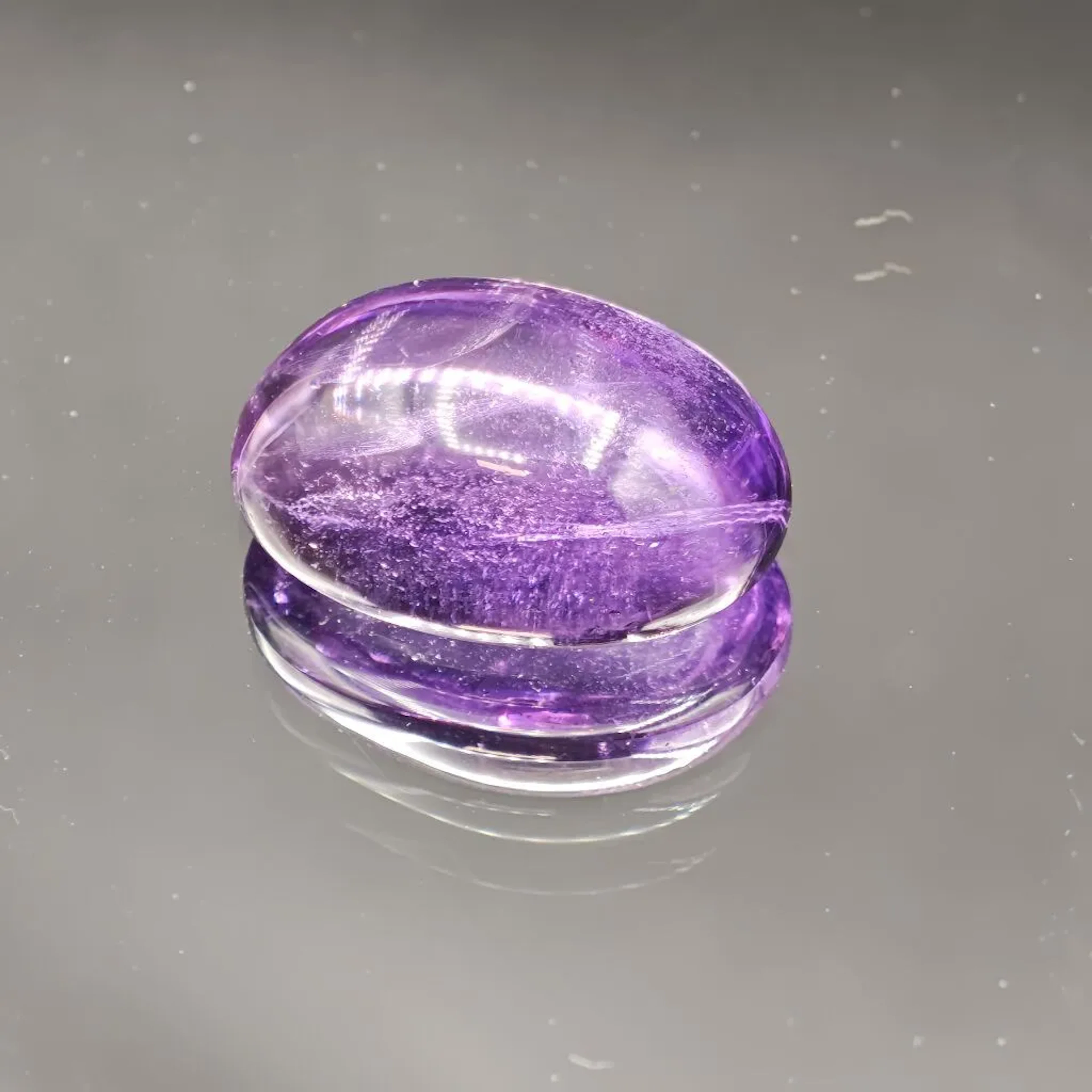 Oval-shaped amethyst, cabochon cut, weighing 25.46 carats. Dimensions: