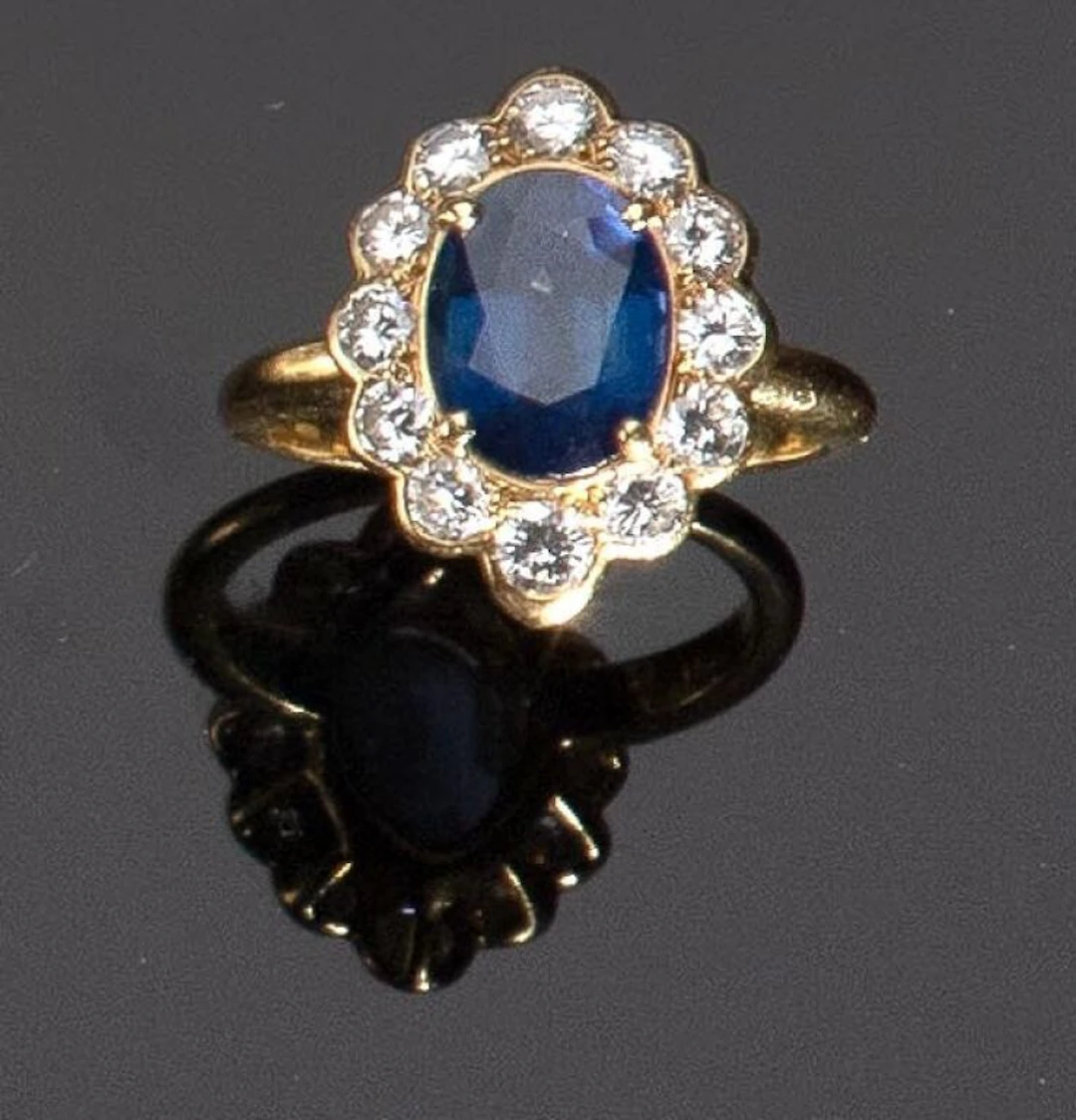 A 750‰ yellow gold ring set with an oval sapphire—likely a heat-treated