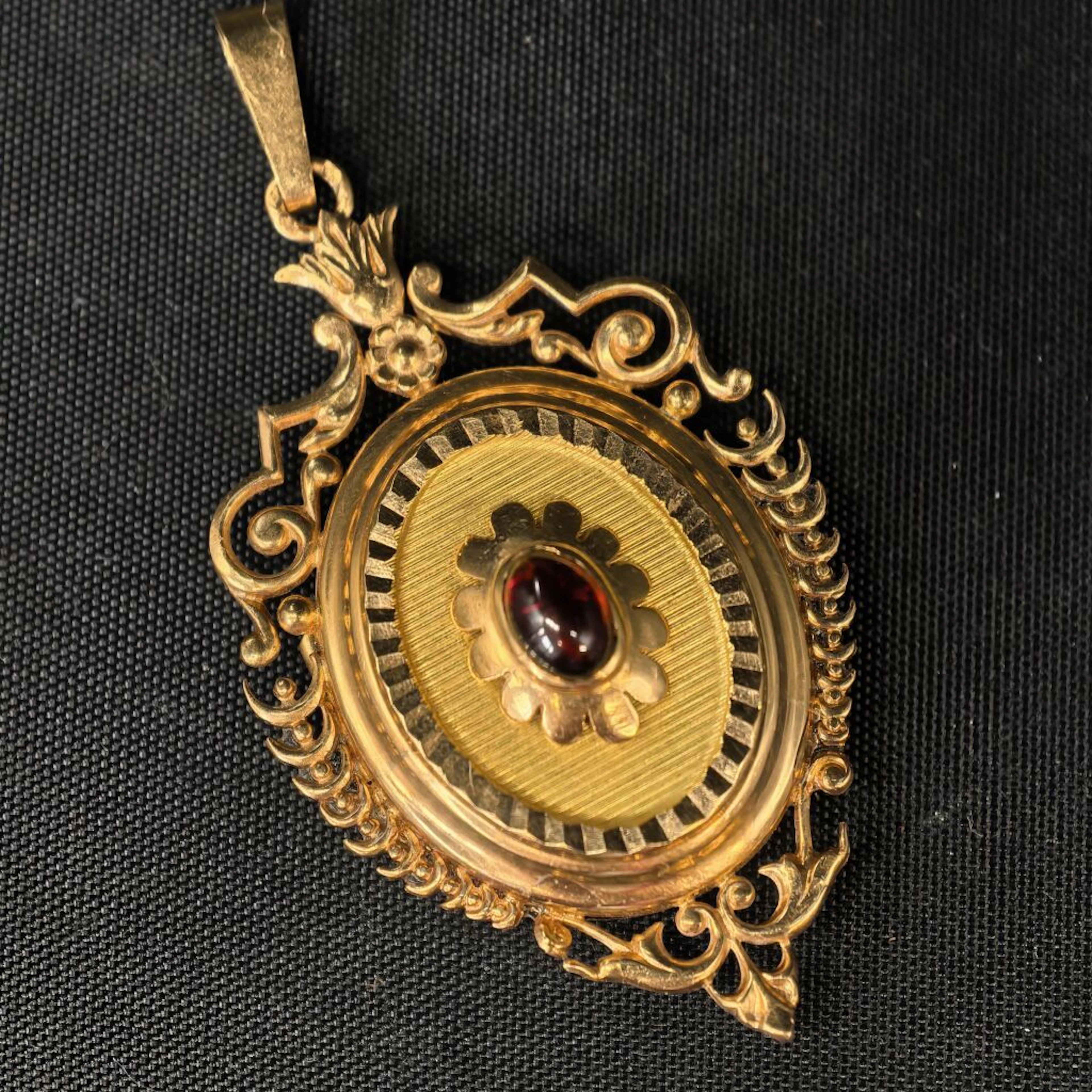 A 750‰ yellow gold photo pendant in the shape of a medallion, featuring