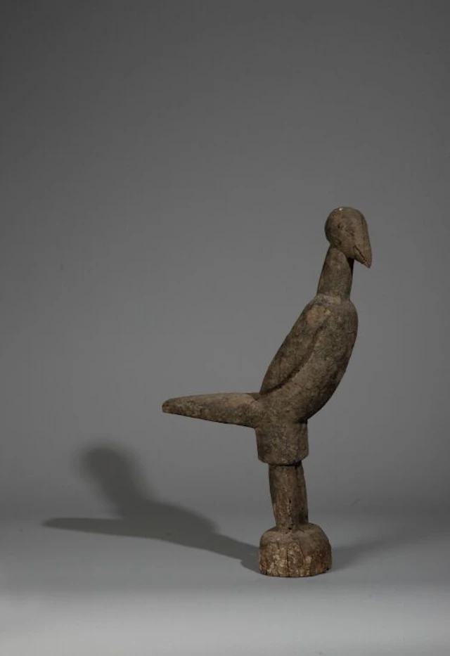 A protective bird used in divination, mounted on a hardwood base with