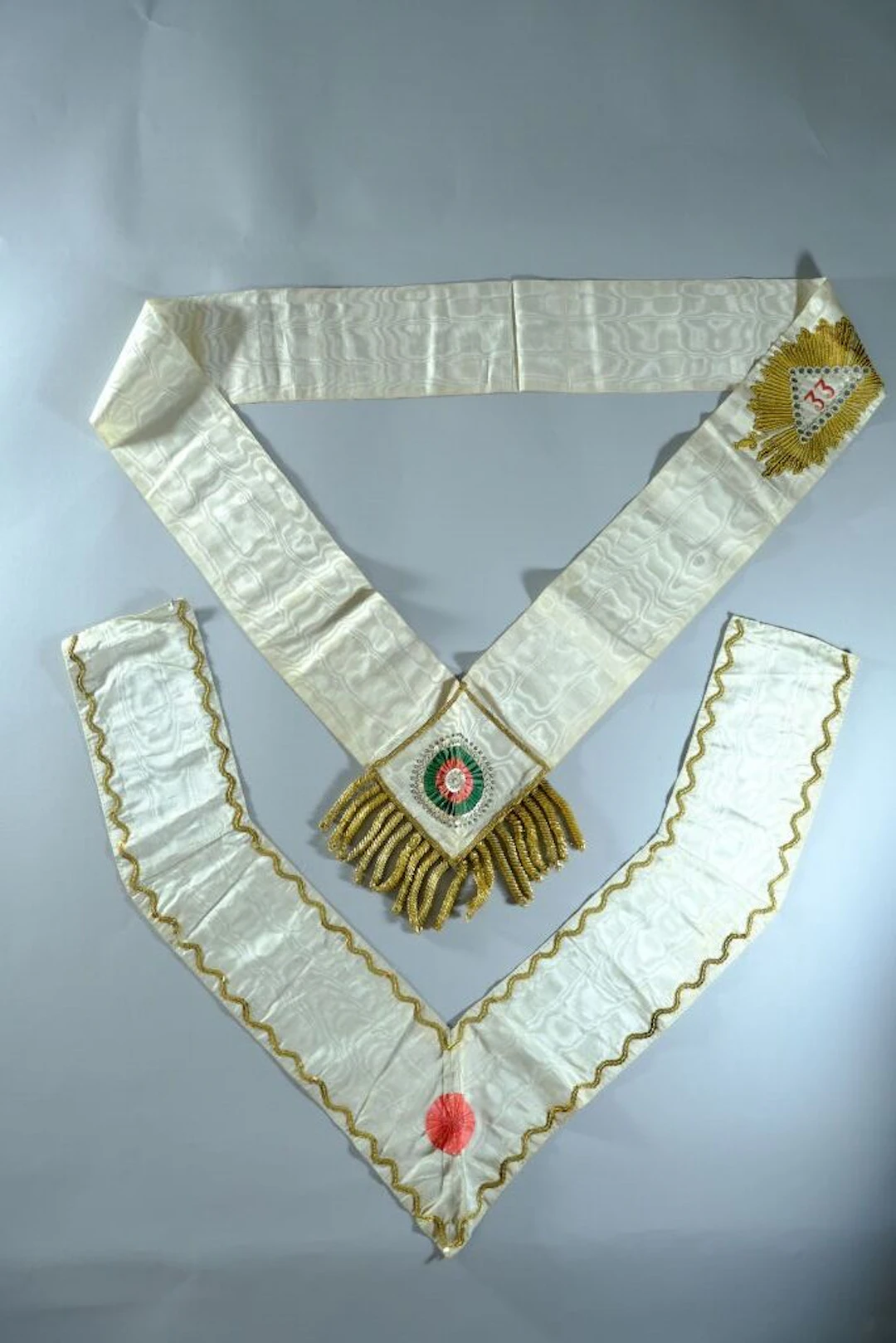 A 33° set, including a necklace and long chain in cream moiré embroidered