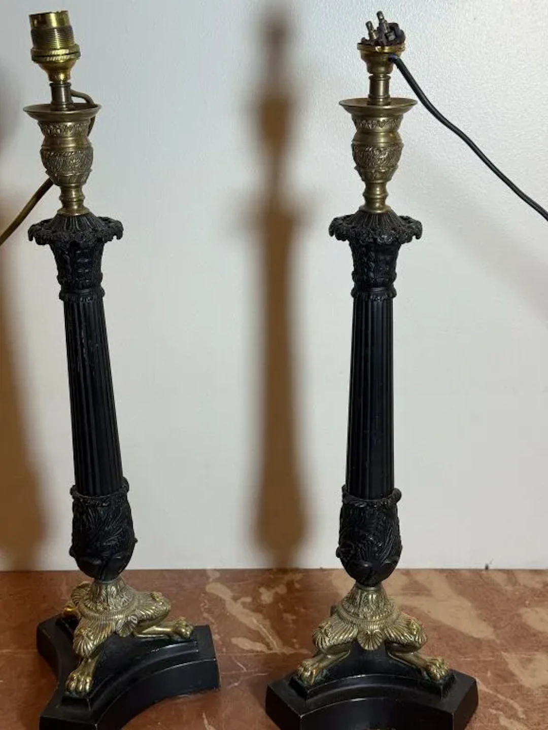 Pair of black-patinated and unfinished bronze candlesticks; the fluted