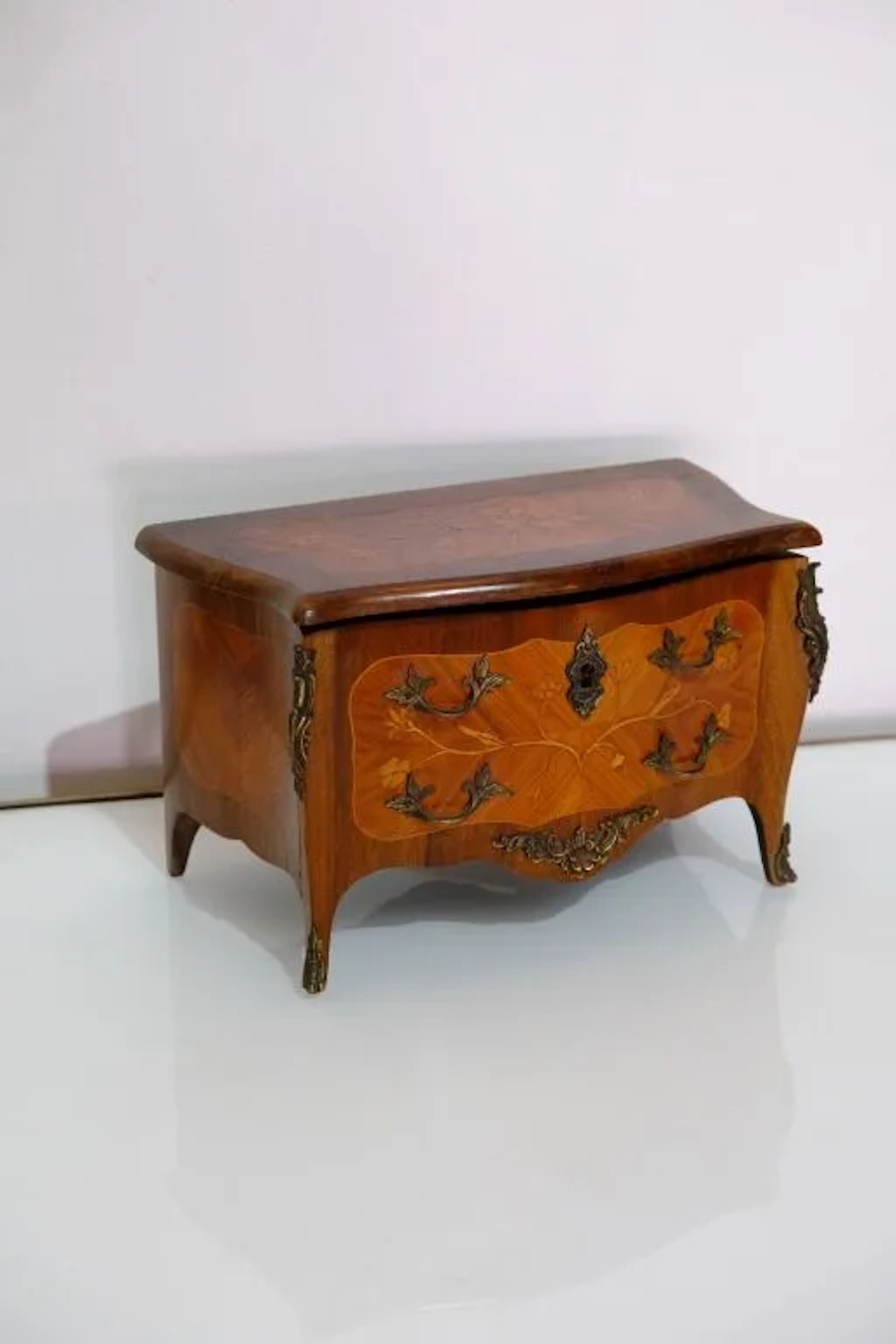 Small veneered wooden chest concealing a jewelry box that opens via