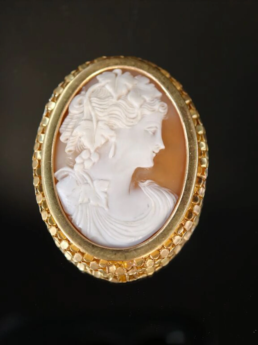 A 750‰ gold brooch featuring a shell cameo set against an openwork